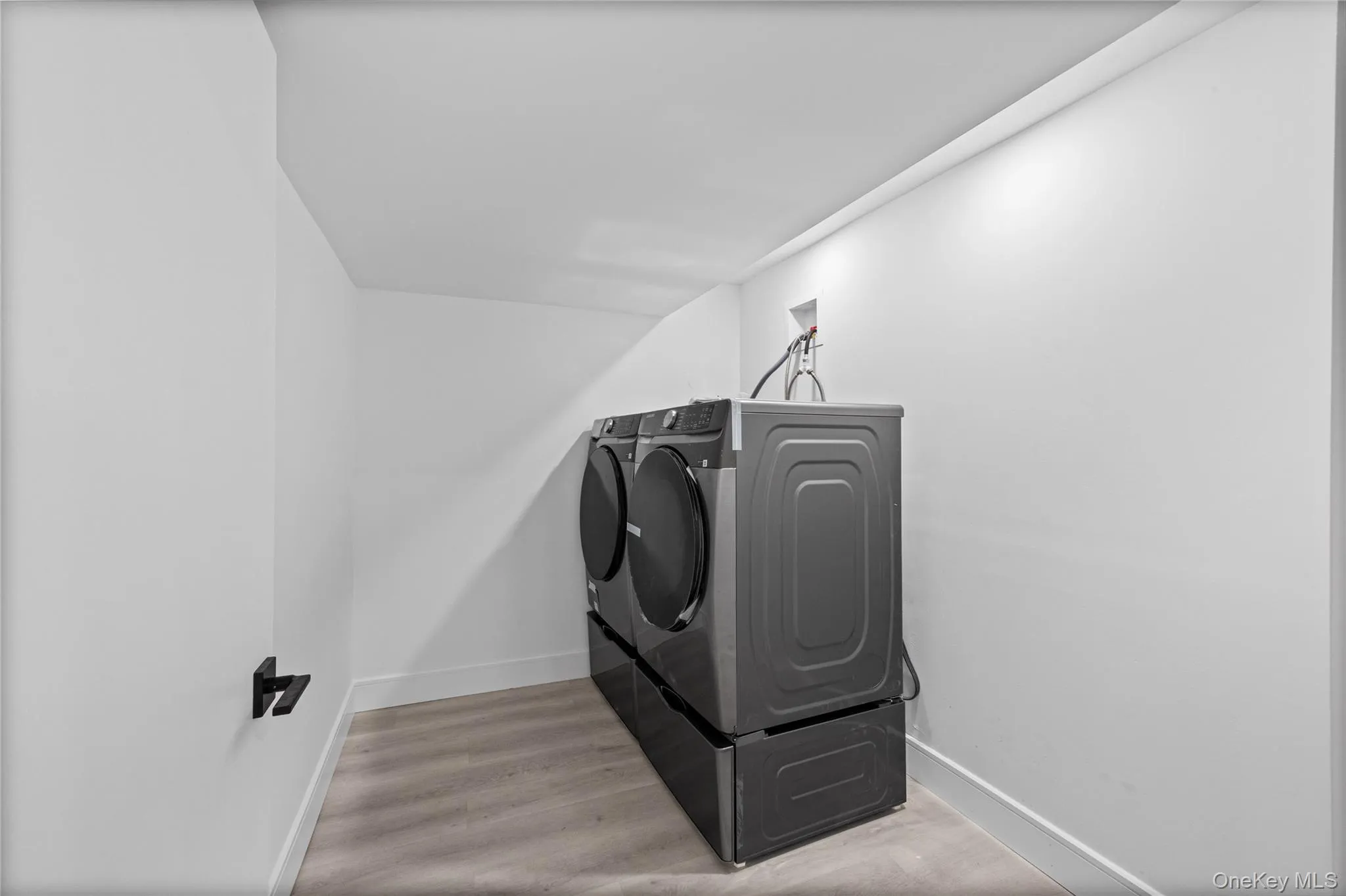 Dedicated laundry area featuring a front-loading washer and dryer set, elevated on pedestals Dedicated laundry area featuring a front-loading washer and dryer set, elevated on pedestals