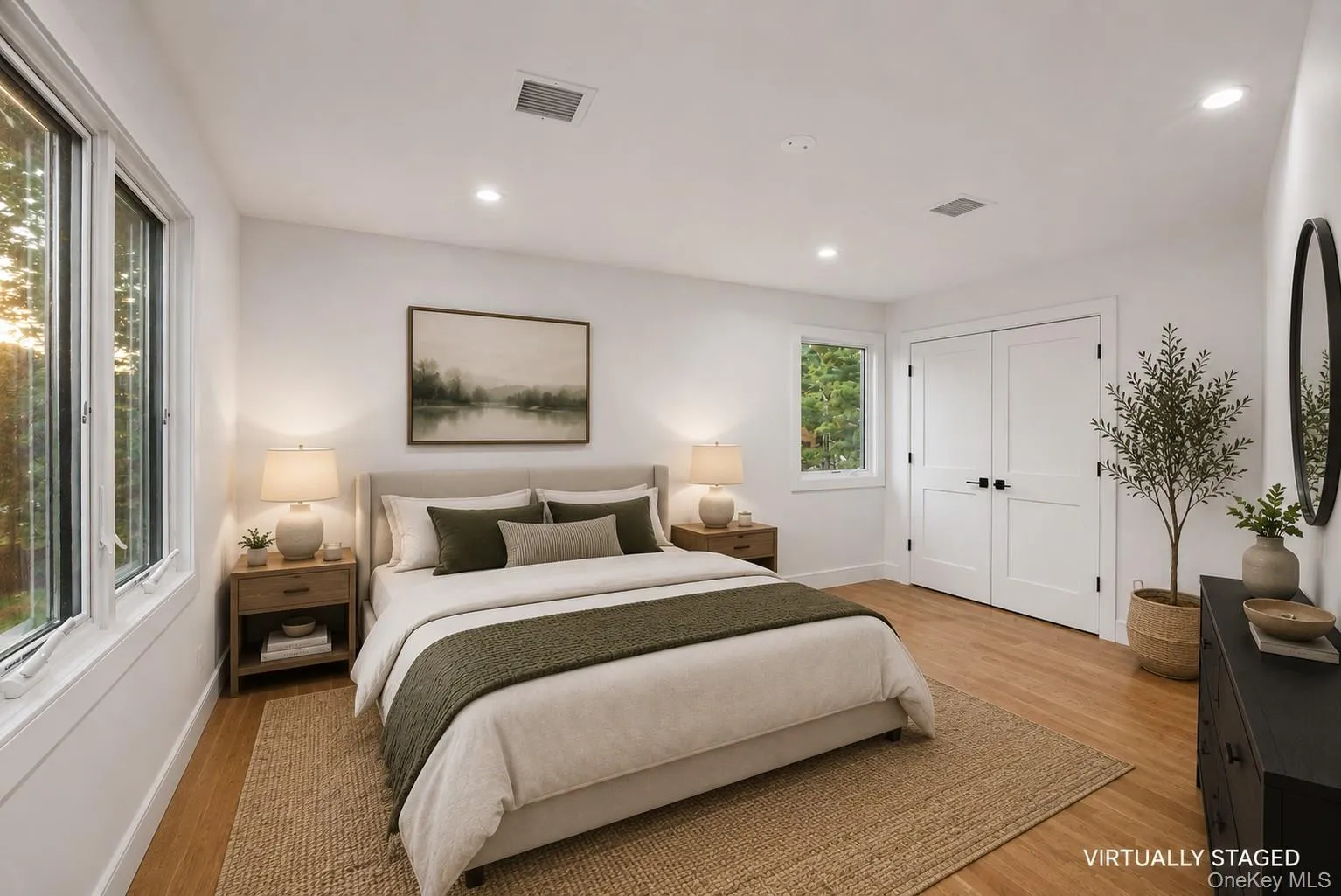 Spacious interior featuring wood-finish flooring, white walls, and recessed lighting Spacious interior featuring wood-finish flooring, white walls, and recessed lighting
