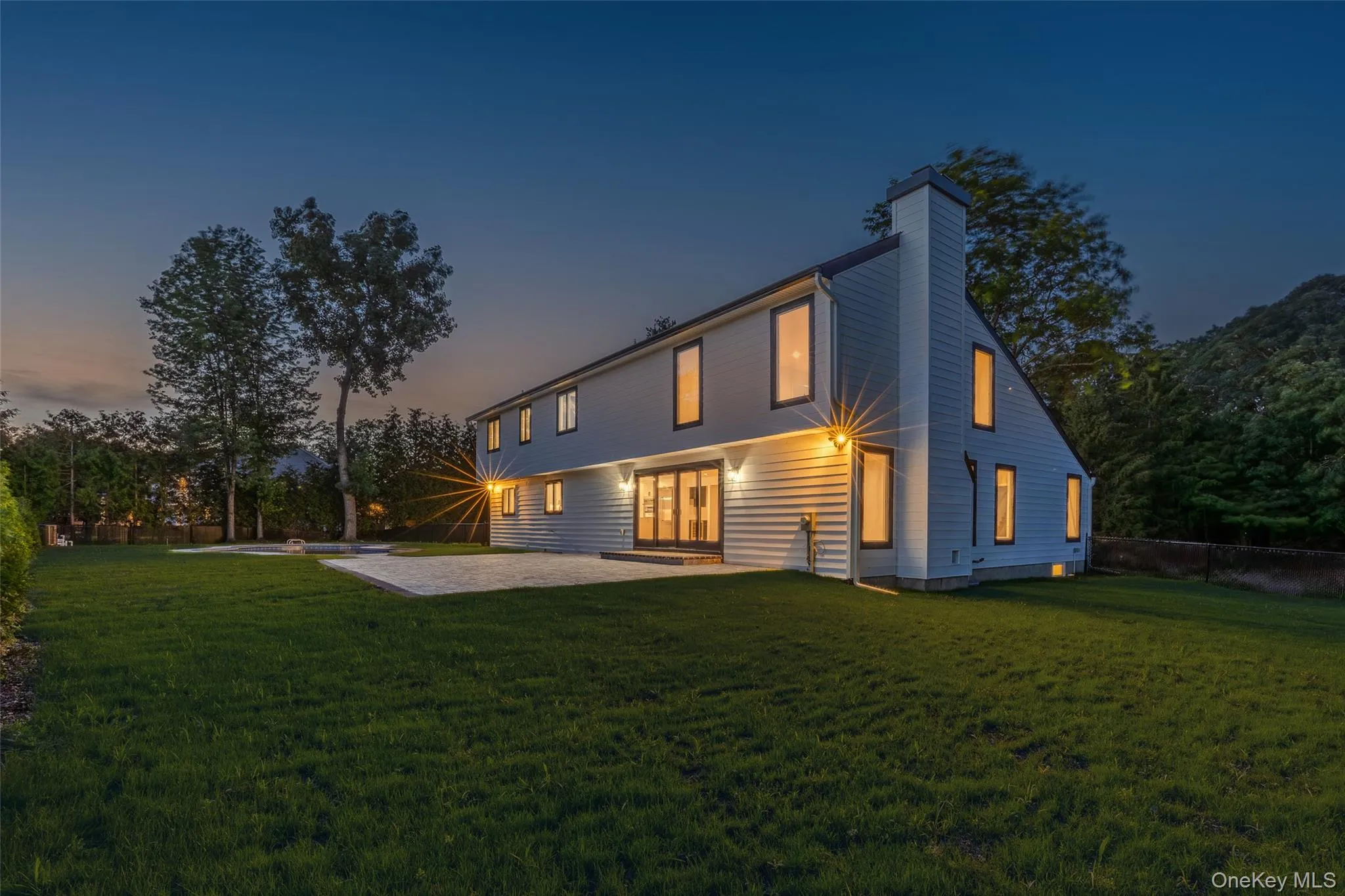 Expansive green lawn with a contemporary two-story residence featuring light-colored siding Expansive green lawn with a contemporary two-story residence featuring light-colored siding