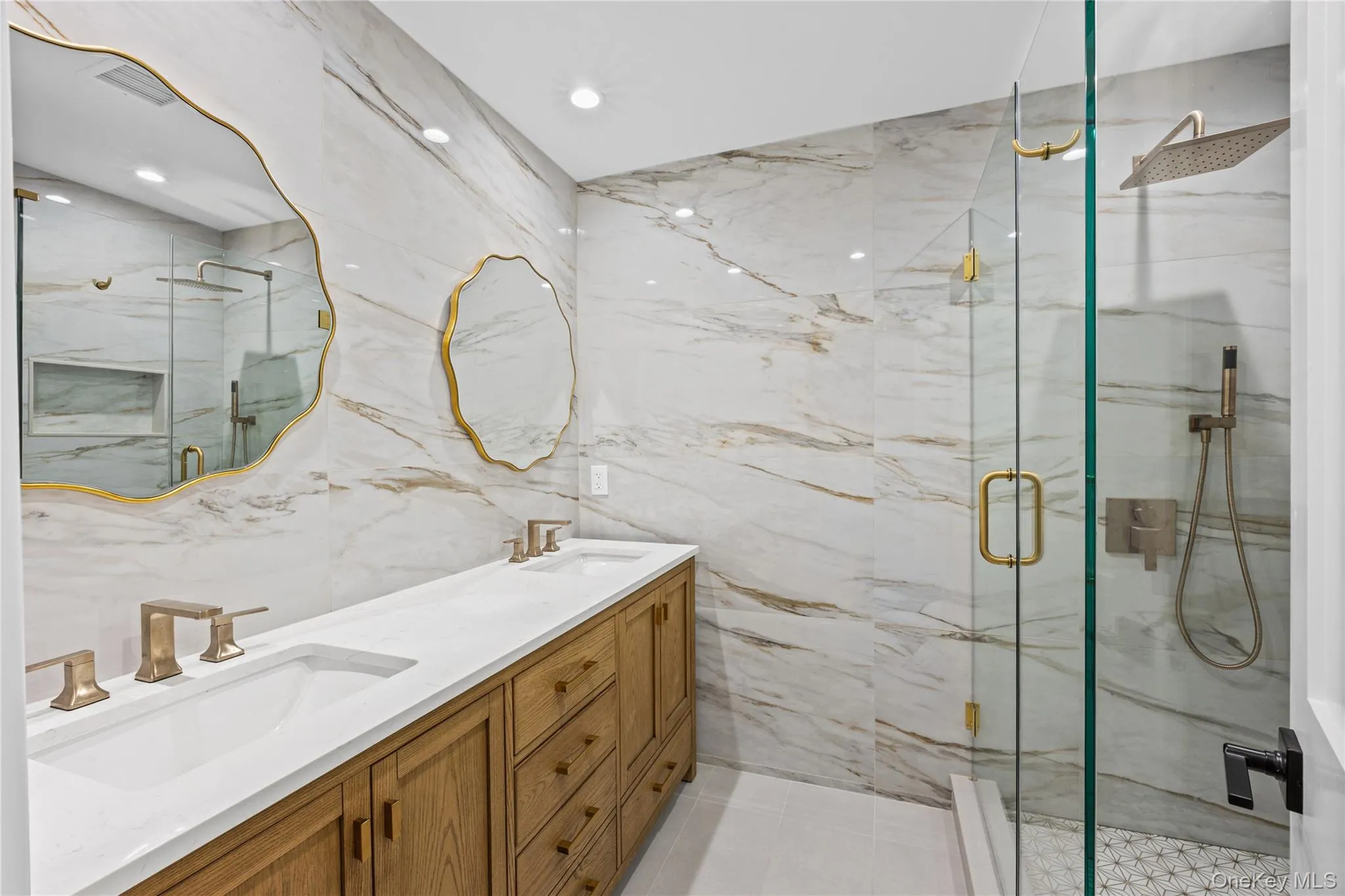Bathroom featuring a double vanity with light wood-finish cabinetry and white countertops. Hallway Bathroom. Bathroom featuring a double vanity with light wood-finish cabinetry and white countertops. Hallway Bathroom.