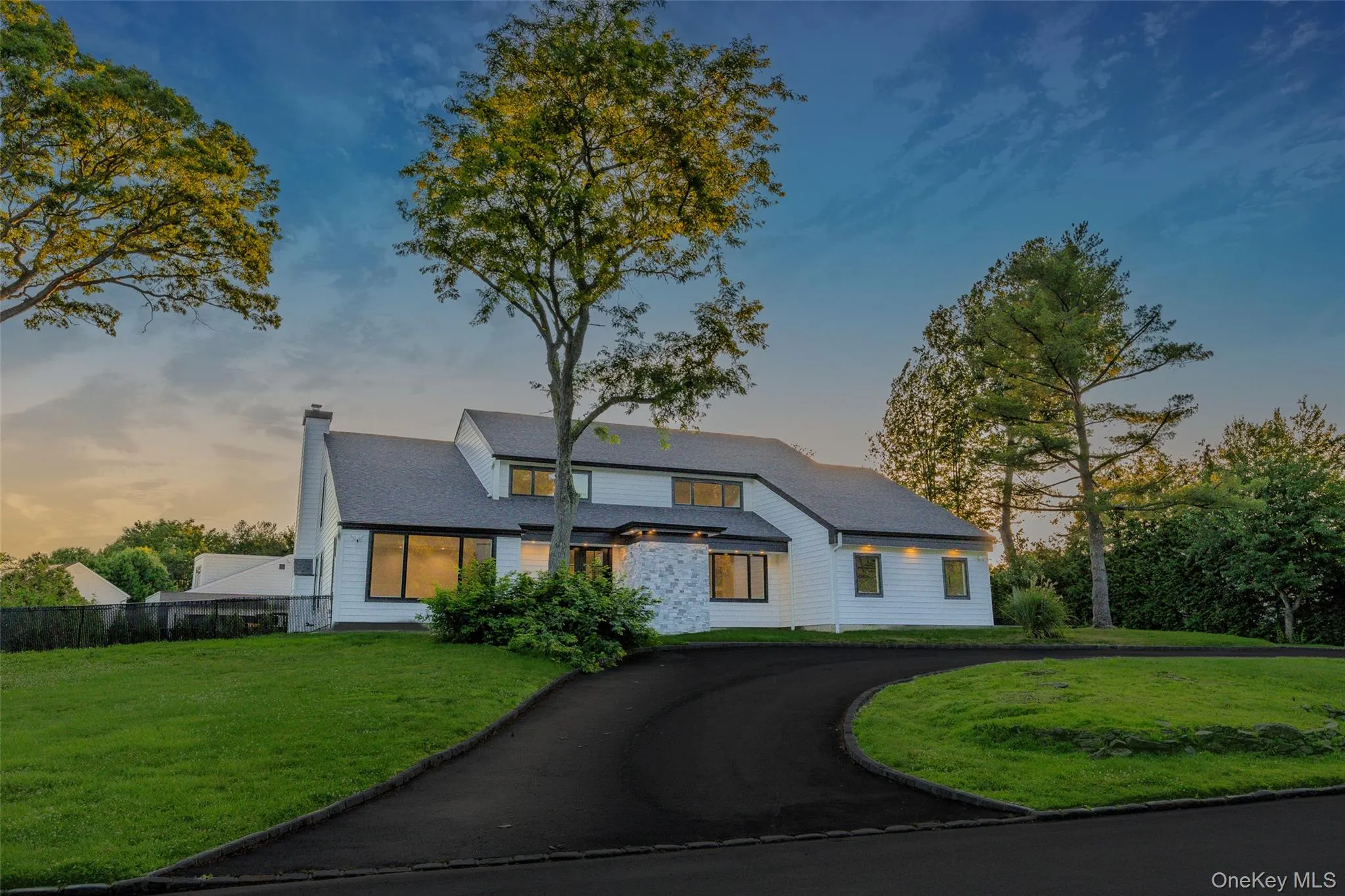 Modern exterior featuring white siding, a dark shingle roof, and a prominent chimney Modern exterior featuring white siding, a dark shingle roof, and a prominent chimney