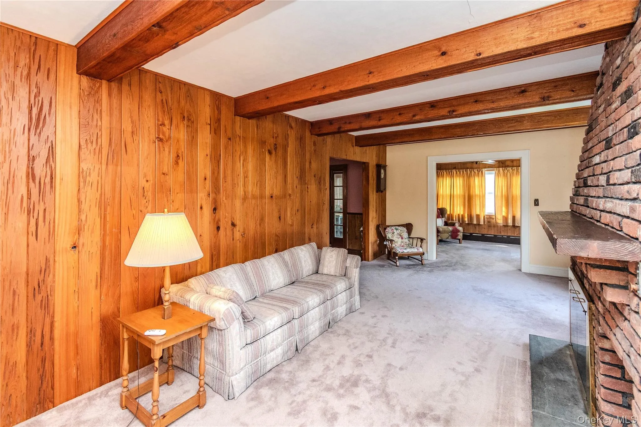 Exposed wood ceiling beams accenting a spacious room with light-toned wall-to-wall carpeting Exposed wood ceiling beams accenting a spacious room with light-toned wall-to-wall carpeting