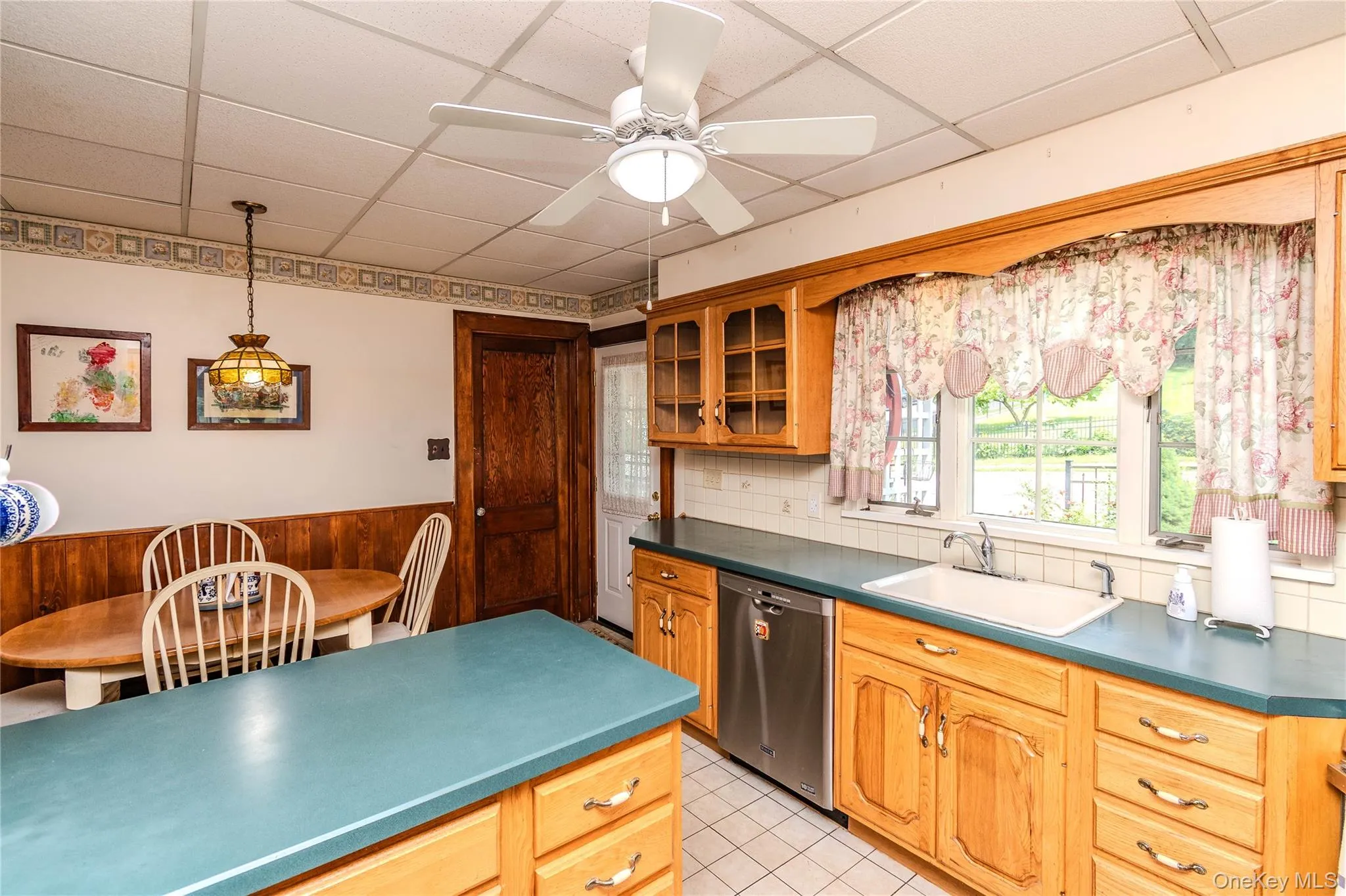 Kitchen featuring ample wood cabinetry, a built-in dishwasher, and a double-basin sink Kitchen featuring ample wood cabinetry, a built-in dishwasher, and a double-basin sink
