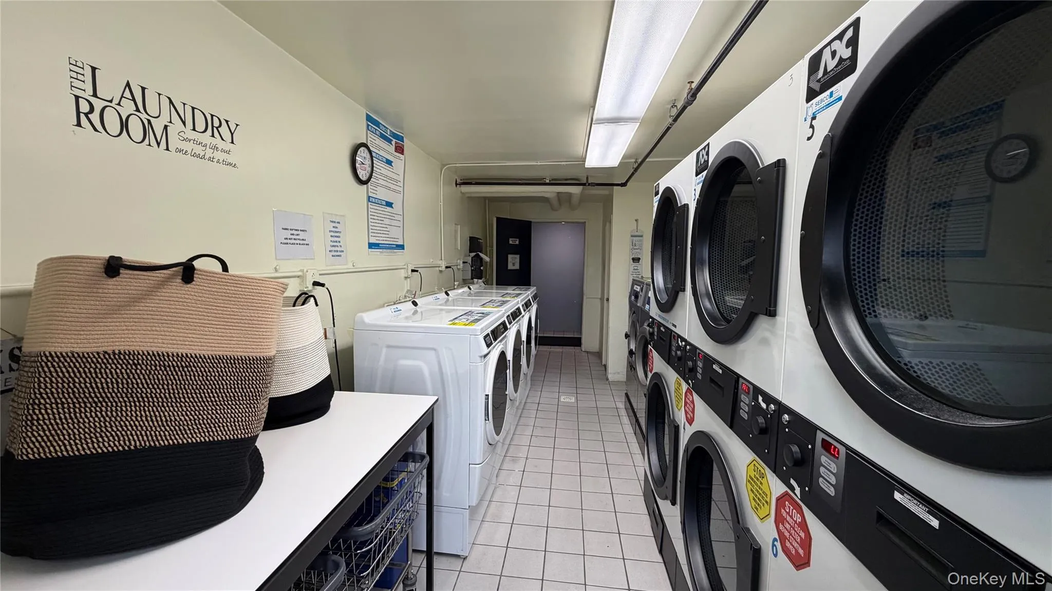 Community laundry room with stacked washing machine and dryer Community laundry room with stacked washing machine and dryer