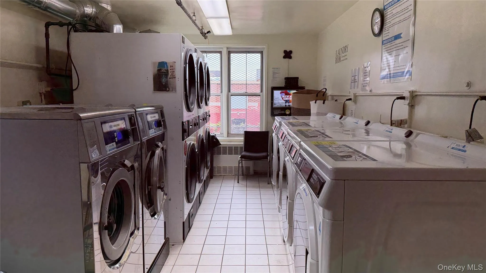 Community laundry featuring washer and dryer, stacked washer / drying machine, and radiator Community laundry featuring washer and dryer, stacked washer / drying machine, and radiator