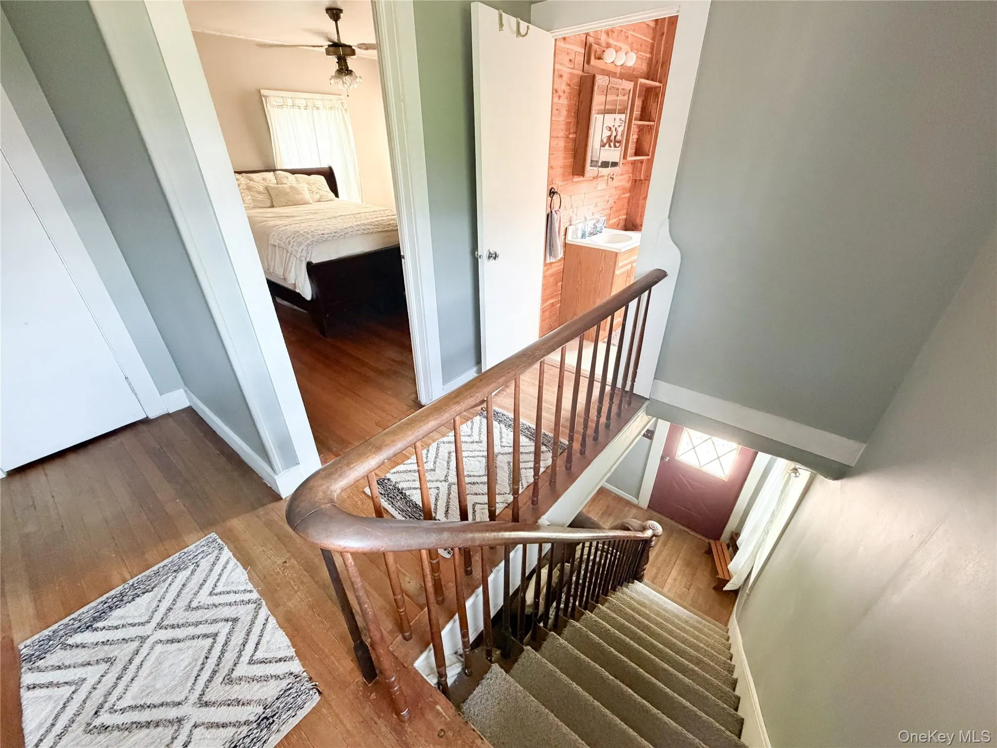 Staircase featuring a wood-finish bannister and carpeted treads Staircase featuring a wood-finish bannister and carpeted treads