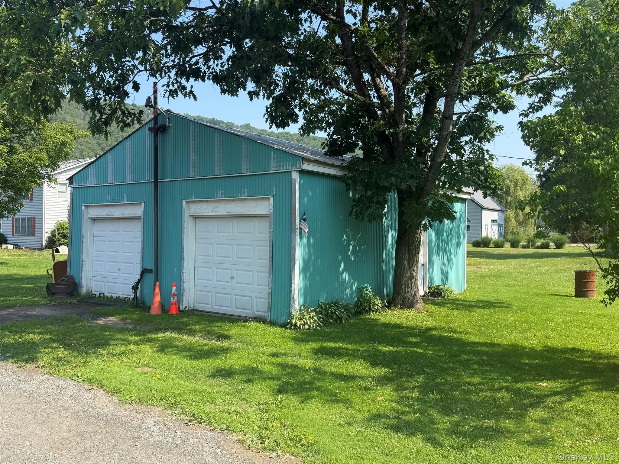 Two-bay corrugated metal garage structure with white panel garage doors Two-bay corrugated metal garage structure with white panel garage doors