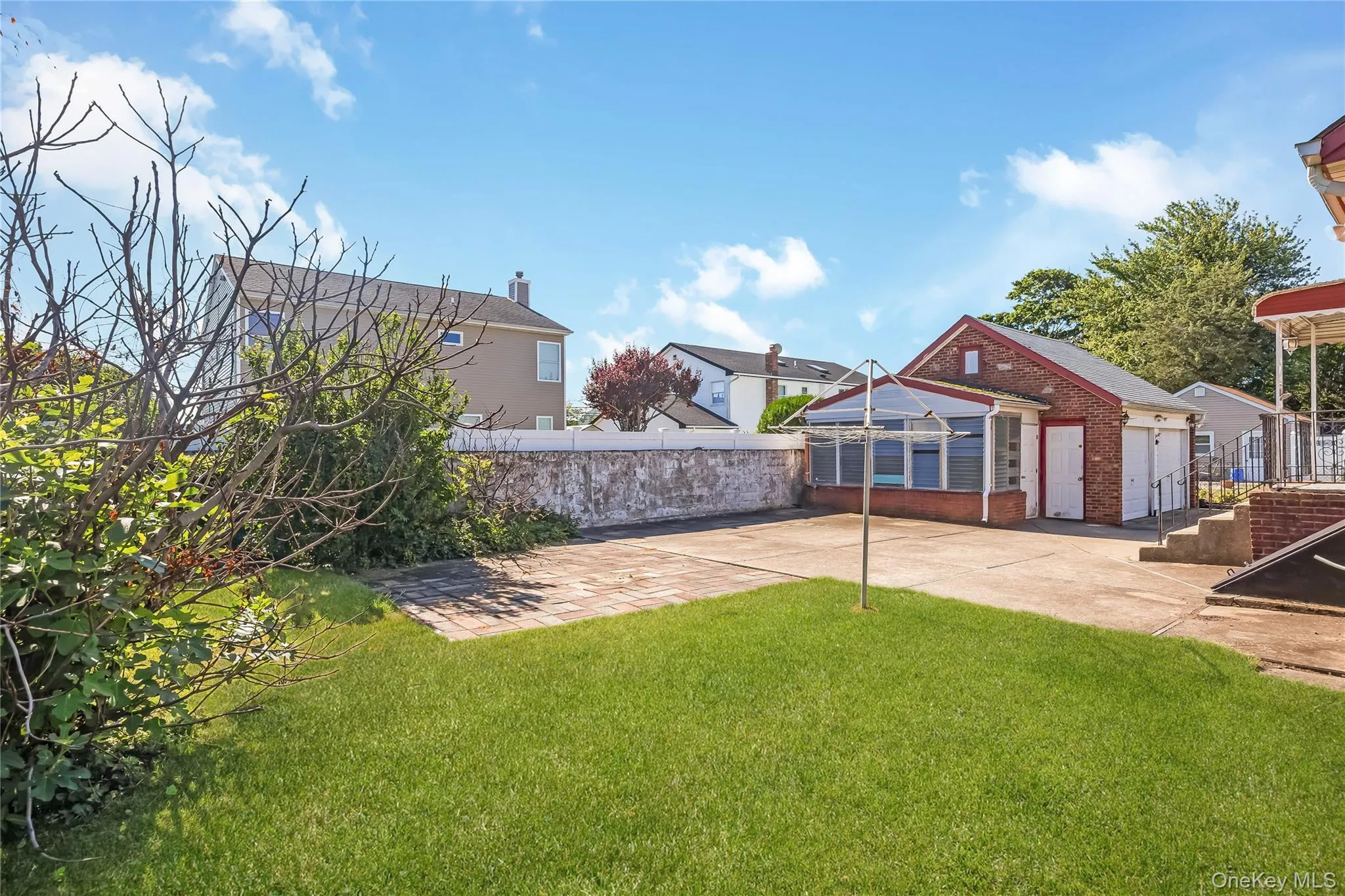 Expansive concrete driveway featuring a brick two car detached garage. Expansive concrete driveway featuring a brick two car detached garage.