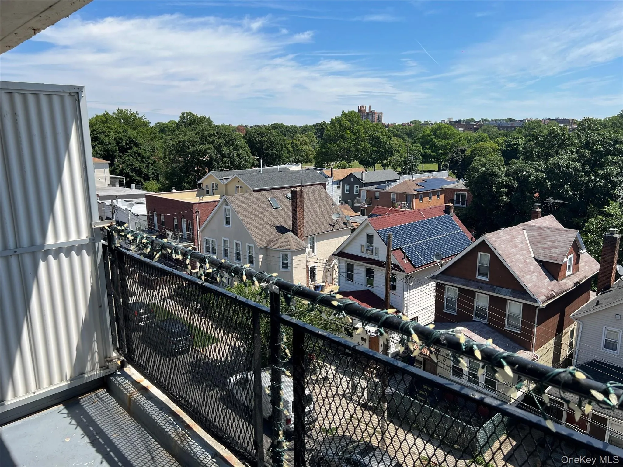 Balcony with metal railing and corrugated metal siding, offering an elevated perspective of the surrounding residential architecture and mature trees Balcony with metal railing and corrugated metal siding, offering an elevated perspective of the surrounding residential architecture and mature trees