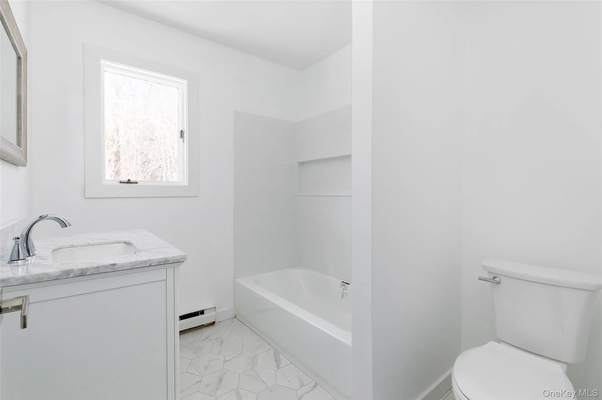 Full bathroom with vanity, bathing tub / shower combination, a baseboard heating unit, and toilet Full bathroom with vanity, bathing tub / shower combination, a baseboard heating unit, and toilet