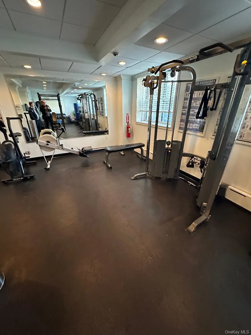 Exercise room featuring a drop ceiling, a baseboard radiator, and recessed lighting Exercise room featuring a drop ceiling, a baseboard radiator, and recessed lighting