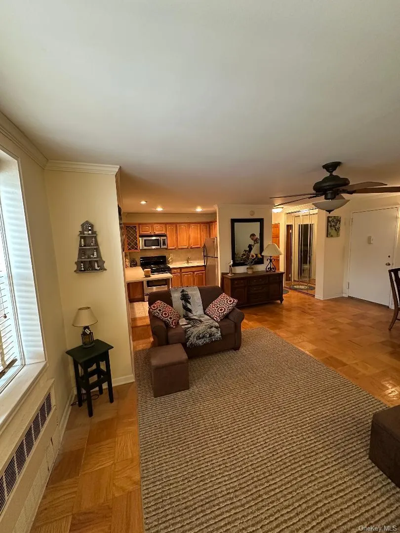 Living room with radiator heating unit, a ceiling fan, and recessed lighting Living room with radiator heating unit, a ceiling fan, and recessed lighting