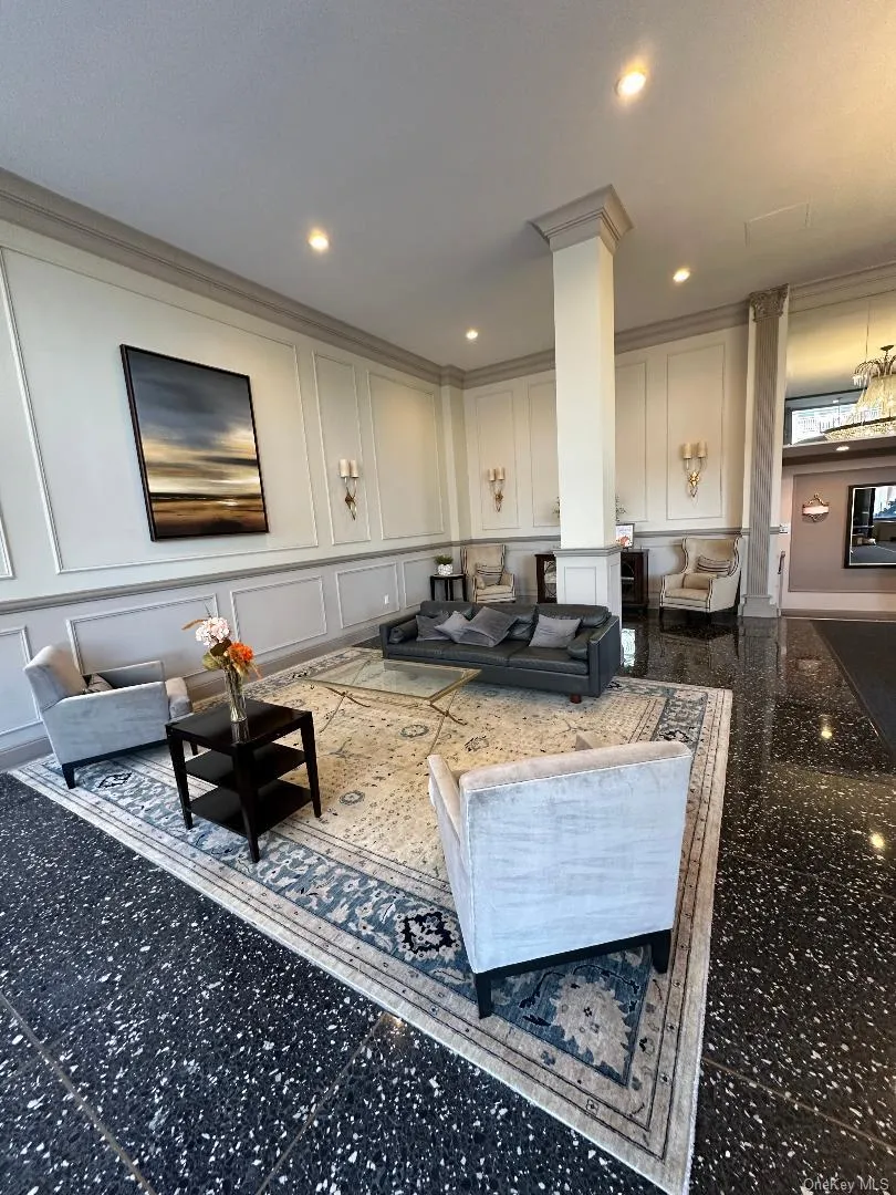 Common area featuring a decorative wall, crown molding, and recessed lighting Common area featuring a decorative wall, crown molding, and recessed lighting