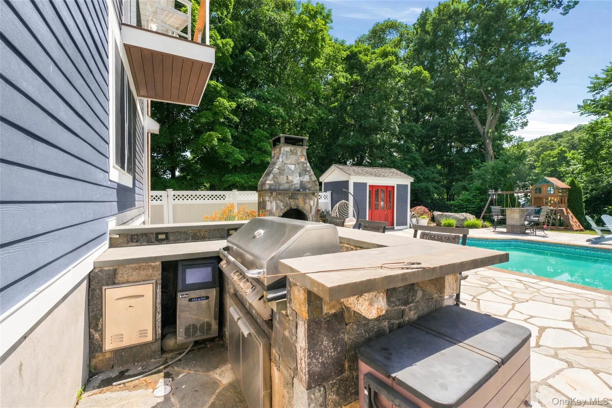 This fully equipped outdoor kitchen overlooks the pool and patio, creating the ultimate entertaining space. With a built-in grill, and stone fireplace nearby, it’s ideal for hosting gatherings. This fully equipped outdoor kitchen overlooks the pool and patio, creating the ultimate entertaining space. With a built-in grill, and stone fireplace nearby, it’s ideal for hosting gatherings.