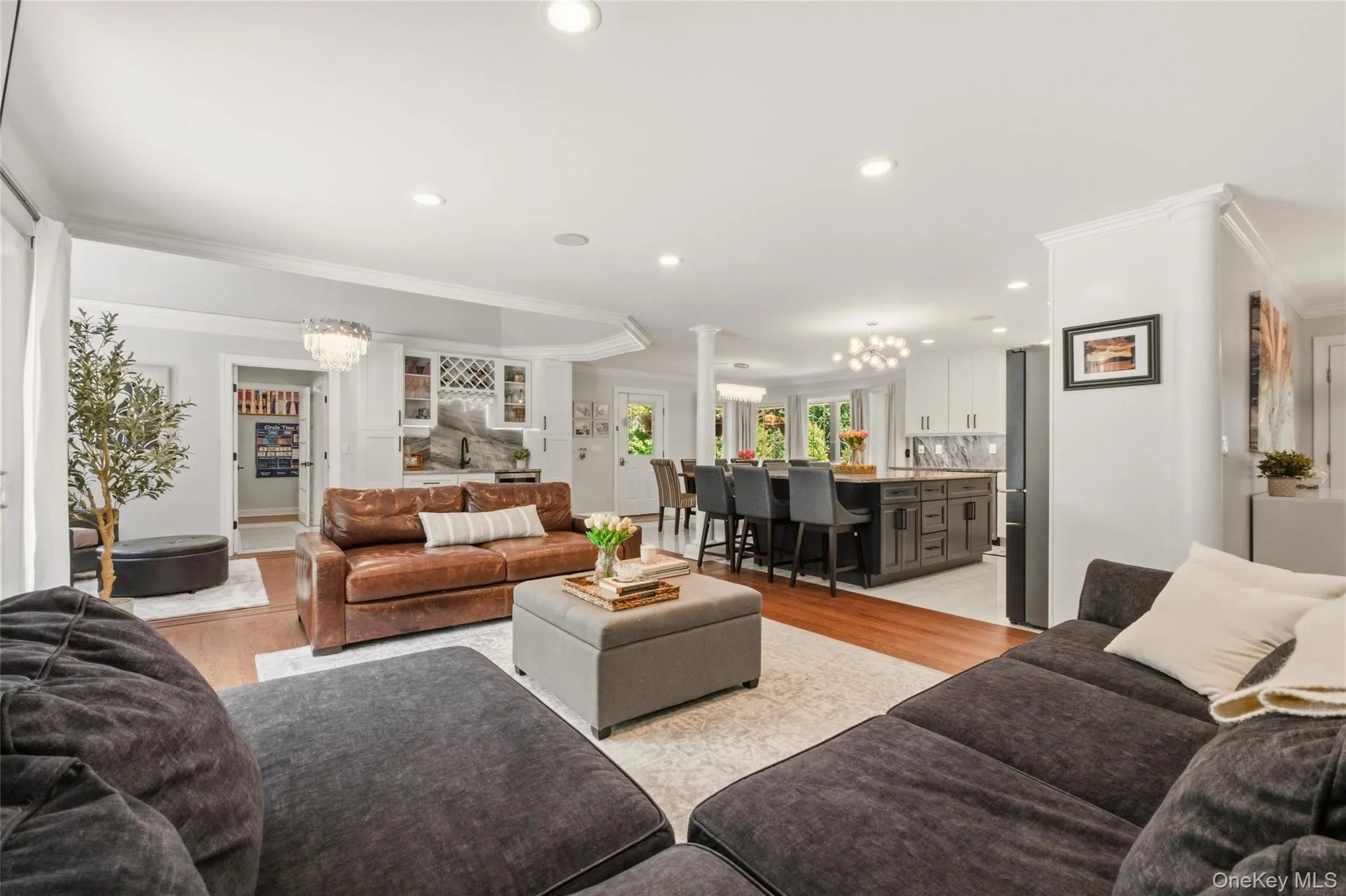 This stunning open-concept main level features a seamless flow between the living room, dining area, and chef’s kitchen. The kitchen impresses with a large island, marble surfaces, elegant lighting, and high-end cabinetry. Natural light pours in through oversized windows, creating a warm, modern, and highly functional gathering space. This stunning open-concept main level features a seamless flow between the living room, dining area, and chef’s kitchen. The kitchen impresses with a large island, marble surfaces, elegant lighting, and high-end cabinetry. Natural light pours in through oversized windows, creating a warm, modern, and highly functional gathering space.