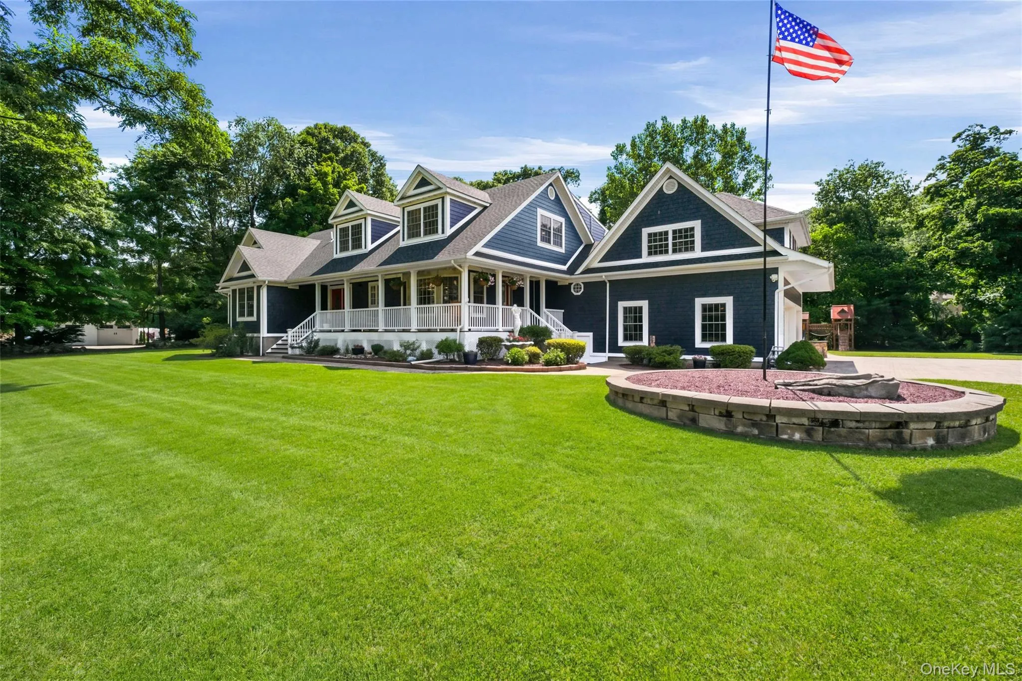 The exterior features a sophisticated blue-gray Hardie sidingwith crisp white trim, gabled rooflines, and dormer windows that add architectural appeal. The large, manicured front lawn, landscaped garden beds, and subtle pathway lighting create a serene, park-like setting. The exterior features a sophisticated blue-gray Hardie sidingwith crisp white trim, gabled rooflines, and dormer windows that add architectural appeal. The large, manicured front lawn, landscaped garden beds, and subtle pathway lighting create a serene, park-like setting.