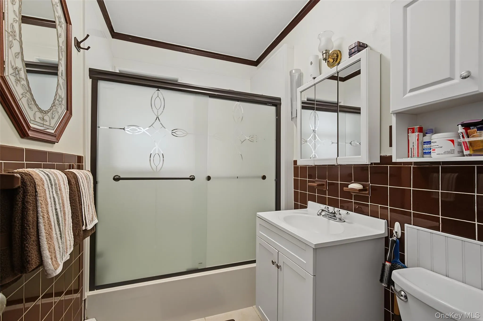Bathroom featuring a white vanity with integrated sink, chrome faucet, and mirrored medicine cabinet Bathroom featuring a white vanity with integrated sink, chrome faucet, and mirrored medicine cabinet