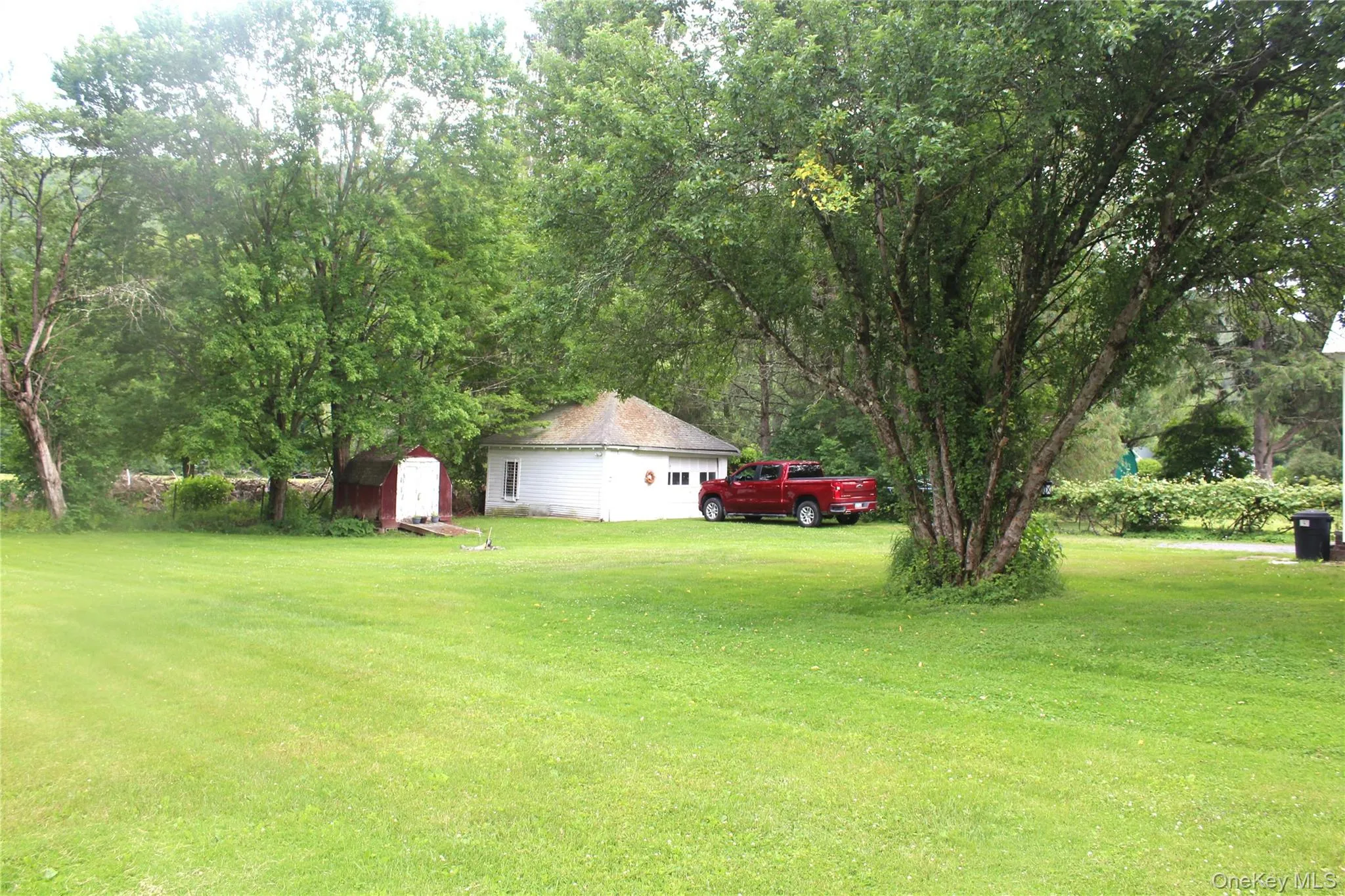 Expansive green lawn with mature trees providing natural shade Expansive green lawn with mature trees providing natural shade