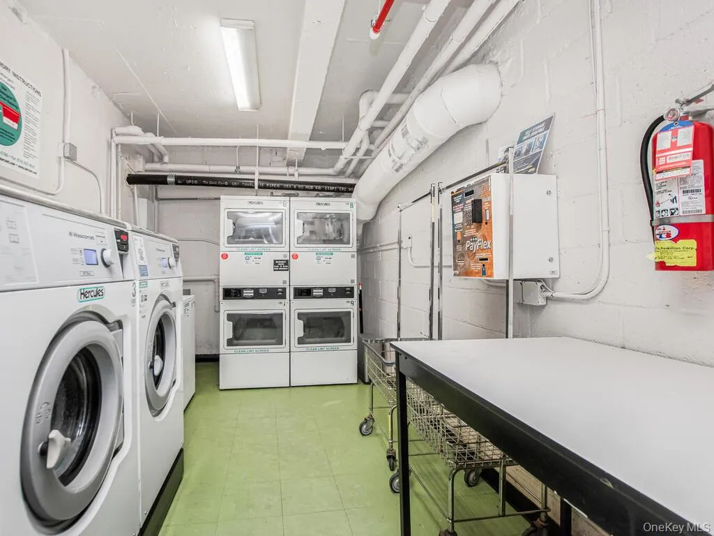 Communal laundry room with stacked washer / drying machine, washing machine and dryer, and tankless water heater Communal laundry room with stacked washer / drying machine, washing machine and dryer, and tankless water heater