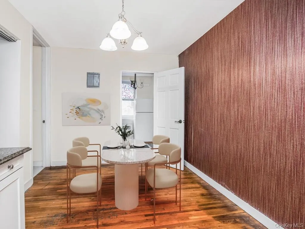 Dining area featuring dark wood-style floors, a chandelier, and wood walls Dining area featuring dark wood-style floors, a chandelier, and wood walls