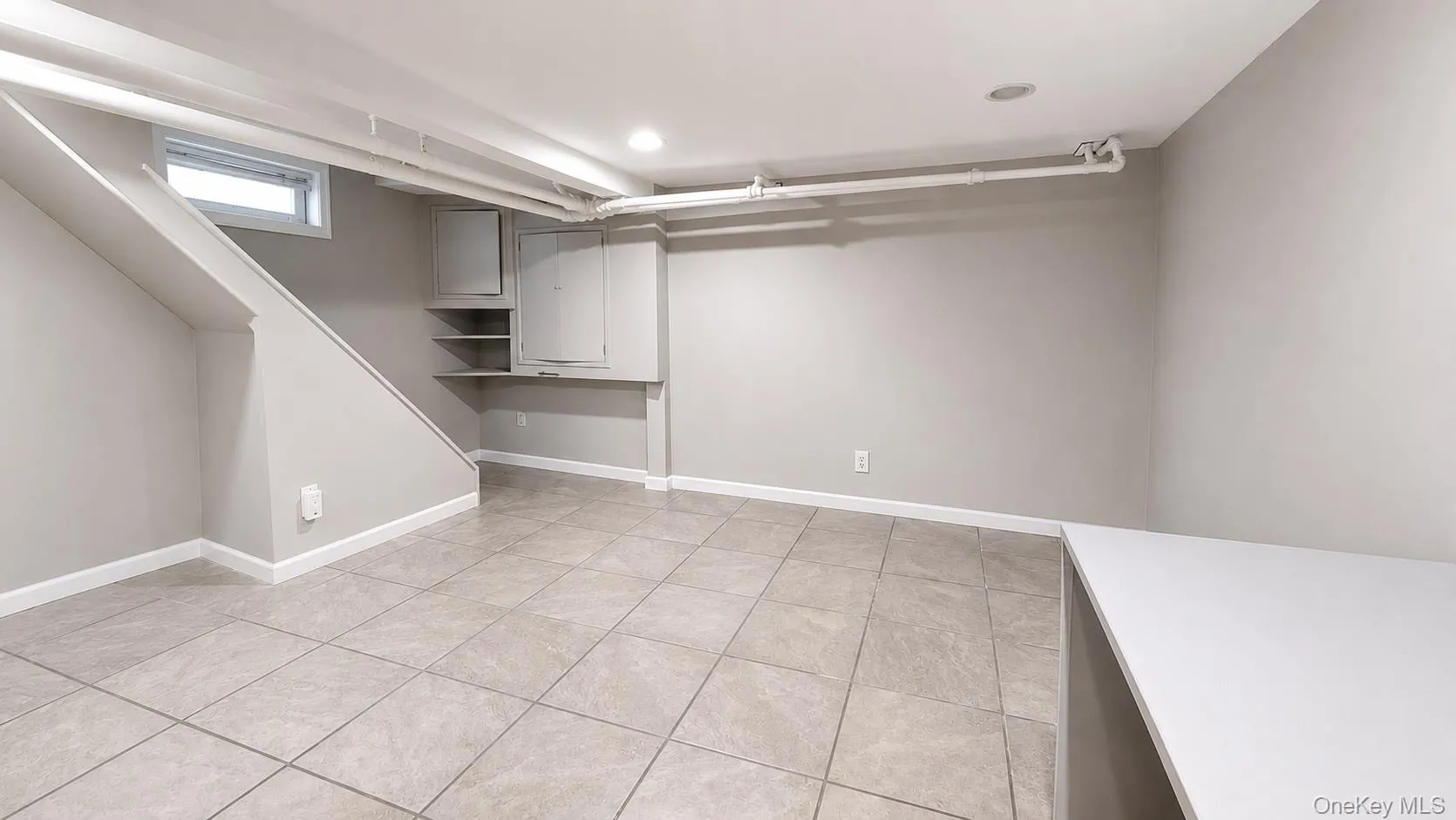 Finished basement section with closet nook, tiled. Finished basement section with closet nook, tiled.
