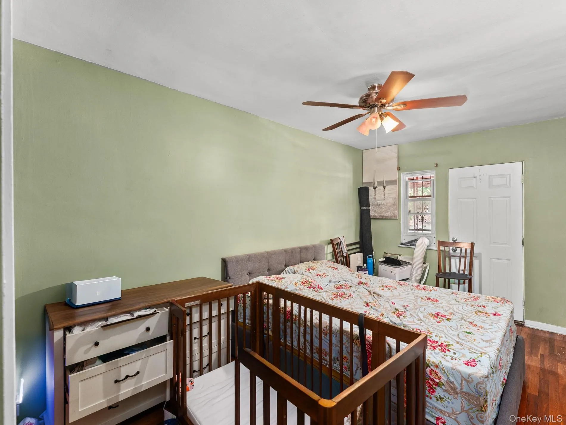 1st. floor, Bedroom featuring light green walls, wood-finish flooring, and a ceiling fan with integrated lighting 1st. floor, Bedroom featuring light green walls, wood-finish flooring, and a ceiling fan with integrated lighting