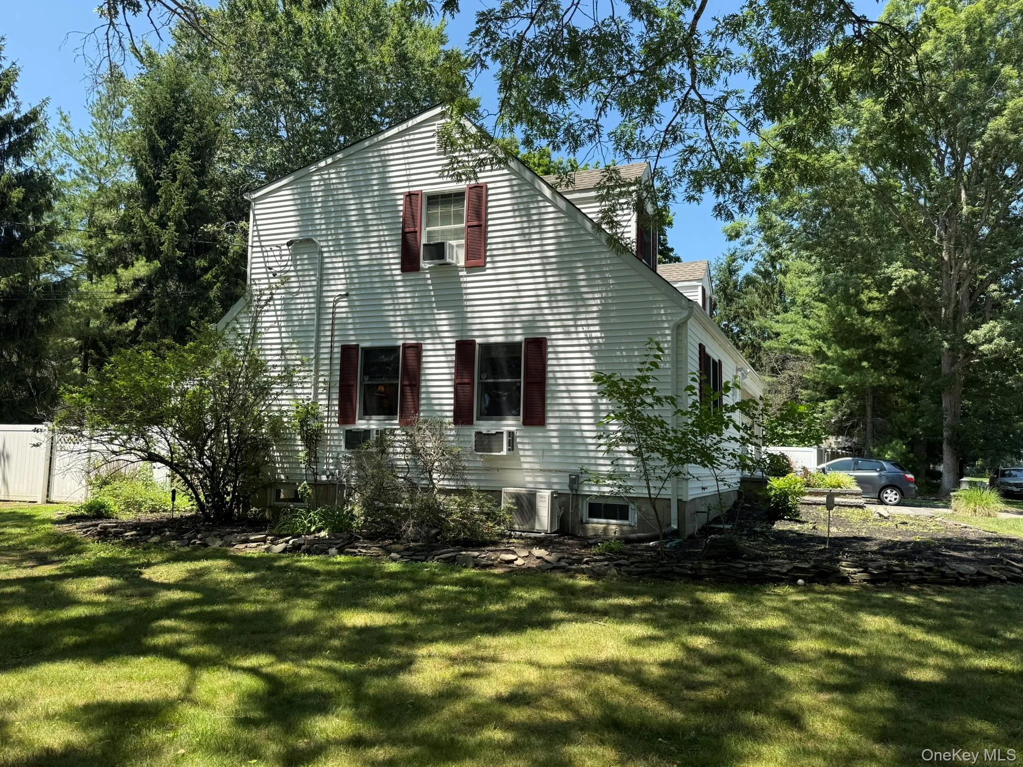 White siding exterior with dark red shutters White siding exterior with dark red shutters