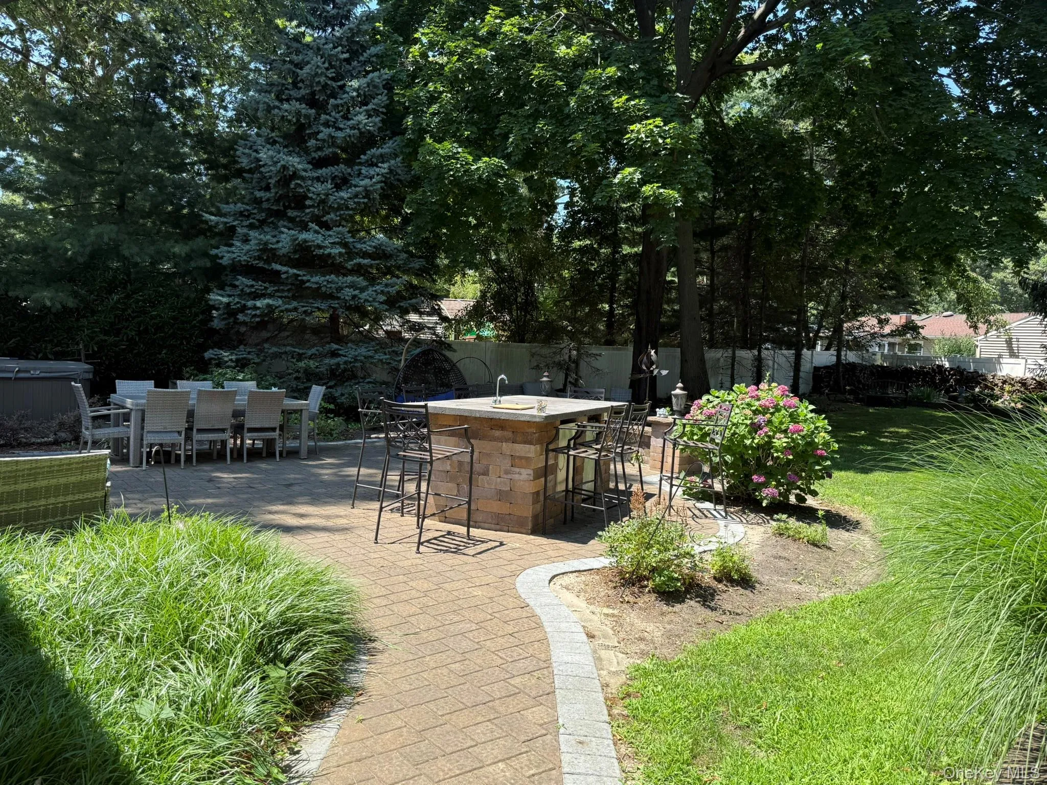 Expansive paver patio with a built-in outdoor kitchen island. View from front gate Expansive paver patio with a built-in outdoor kitchen island. View from front gate