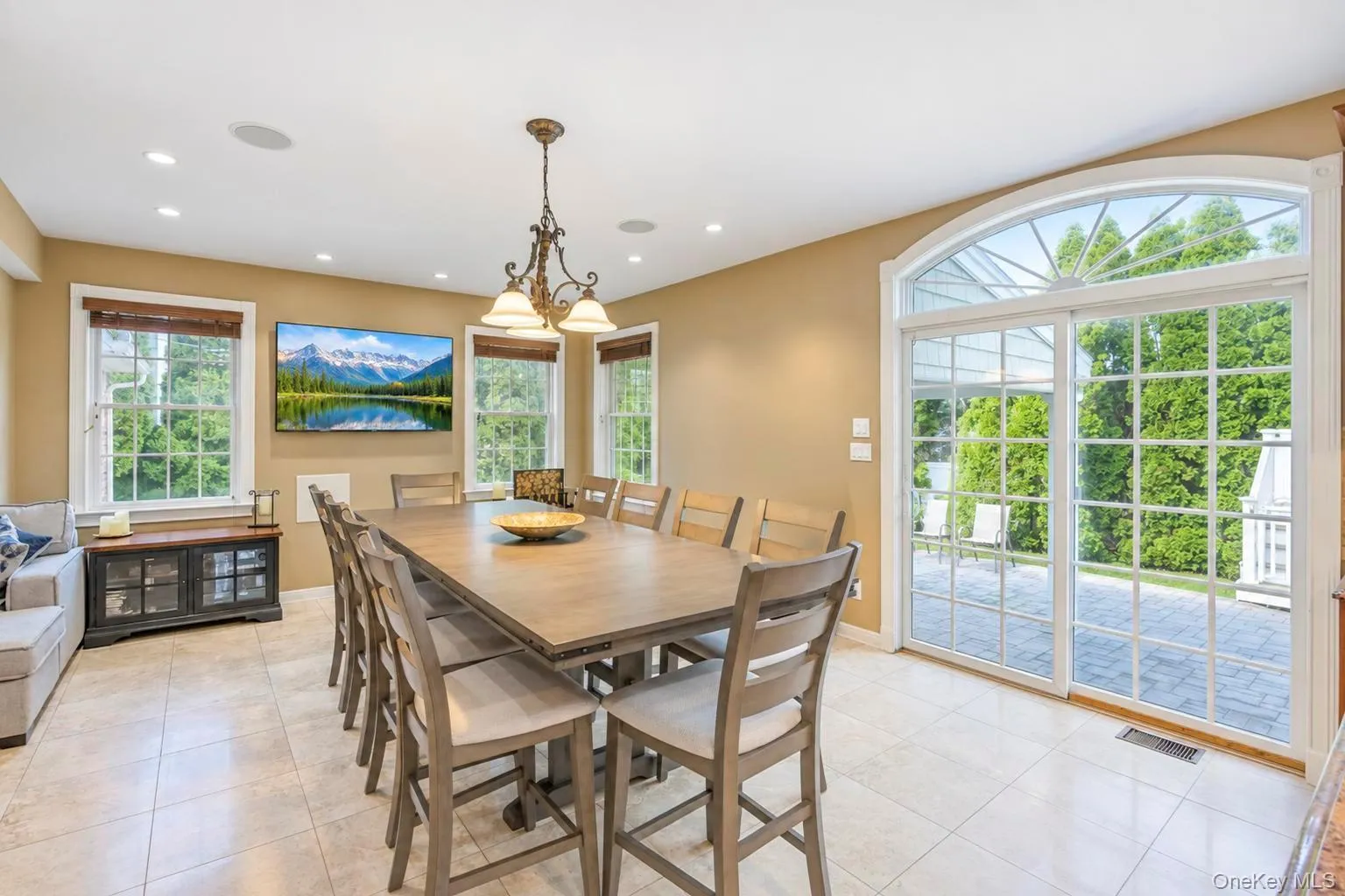 large dining table off kitchen ,Tiled flooring, recessed lighting, and a chandelier illuminate this space featuring multiple windows large dining table off kitchen ,Tiled flooring, recessed lighting, and a chandelier illuminate this space featuring multiple windows