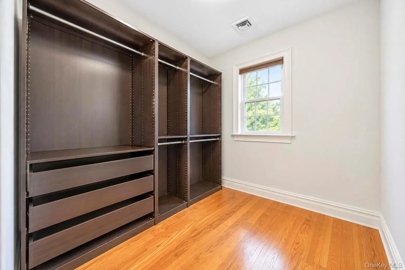 Hardwood flooring, custom built-in closet system with drawers and shelving, double-hung window, crown molding Hardwood flooring, custom built-in closet system with drawers and shelving, double-hung window, crown molding