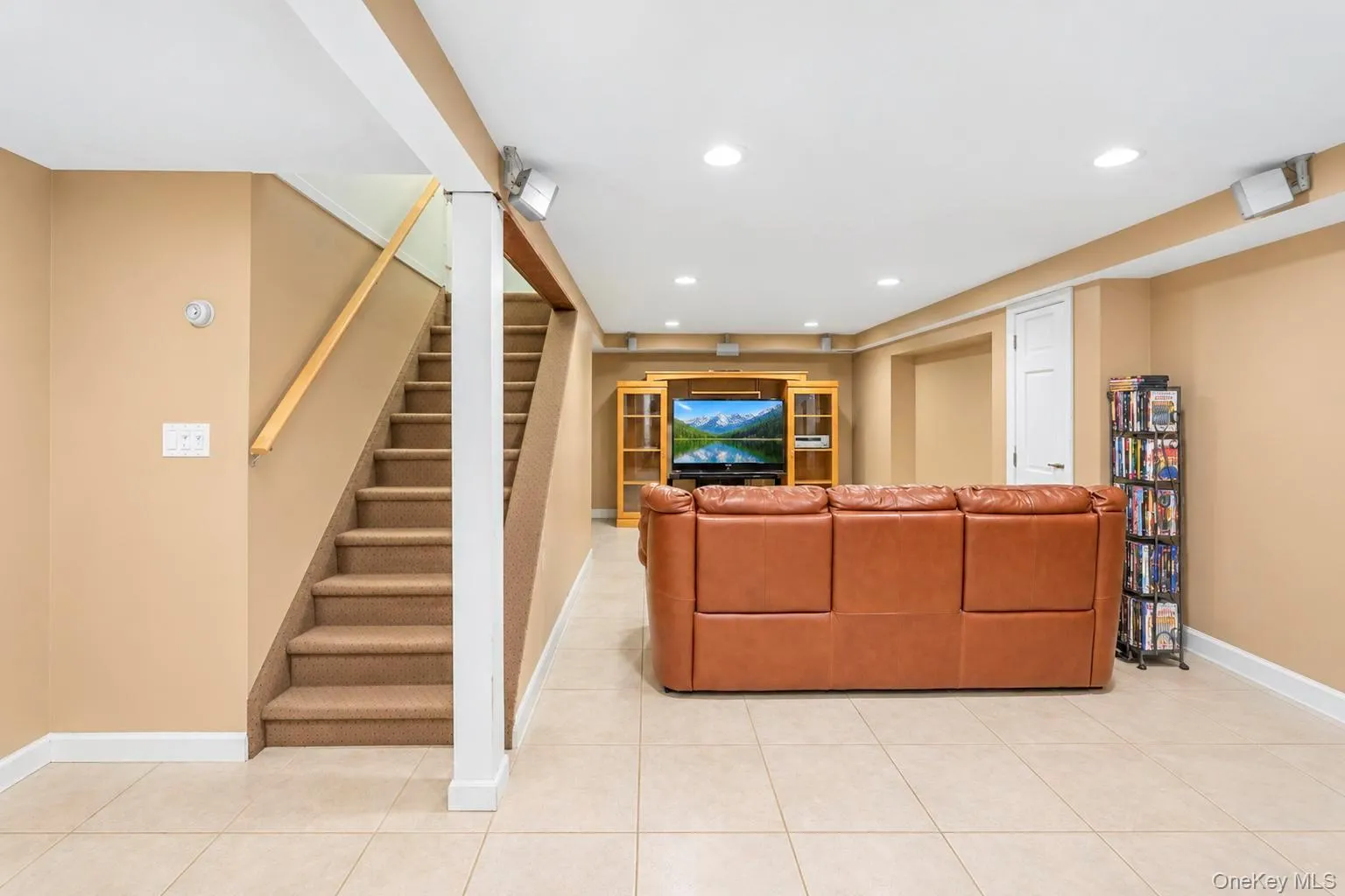 Recessed lighting illuminates this expansive space featuring tile flooring and a built-in media center Recessed lighting illuminates this expansive space featuring tile flooring and a built-in media center