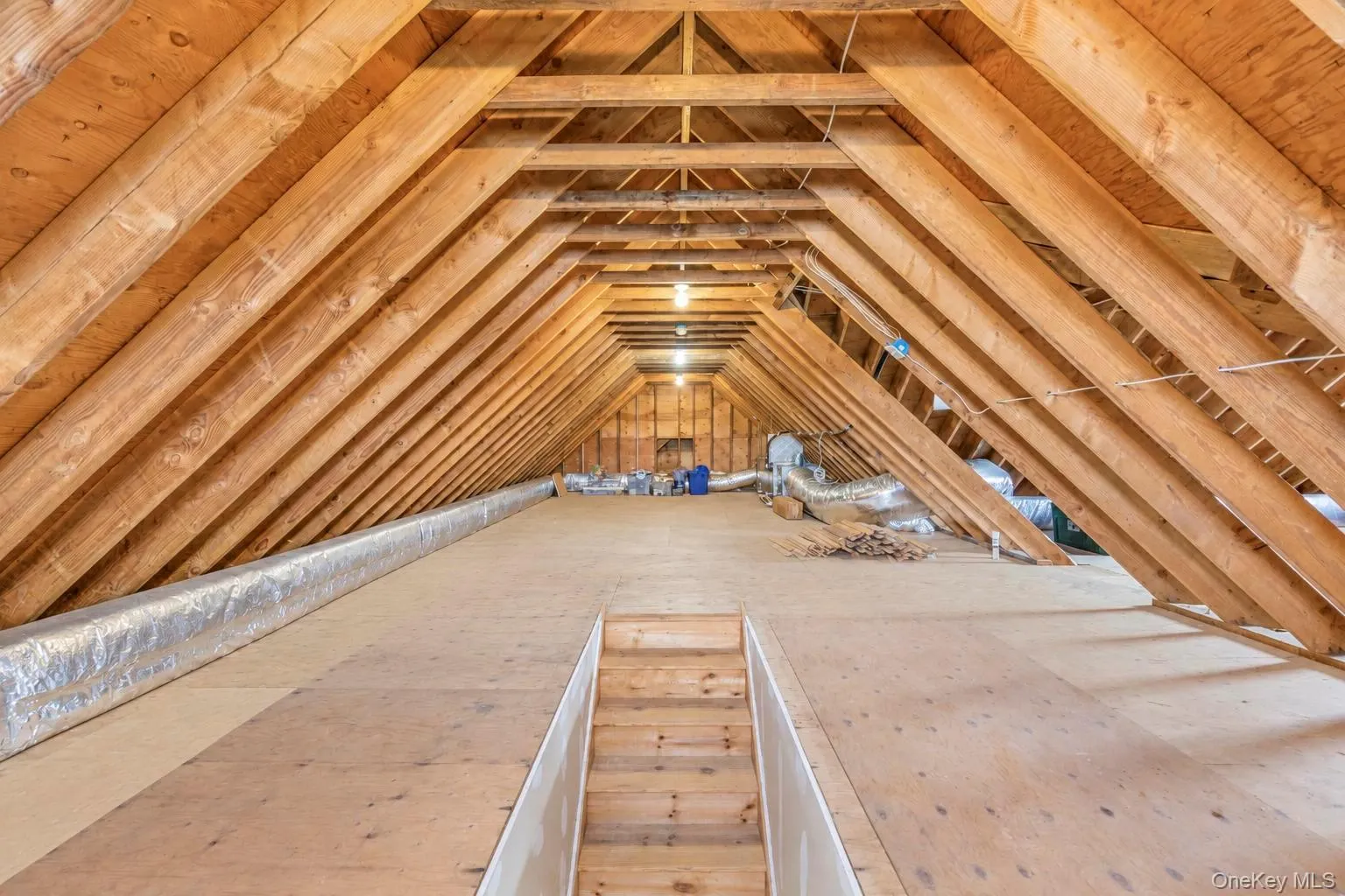 Steps to full attic ,Exposed wood rafters, plywood flooring, and ceiling-mounted lighting fixtures Steps to full attic ,Exposed wood rafters, plywood flooring, and ceiling-mounted lighting fixtures