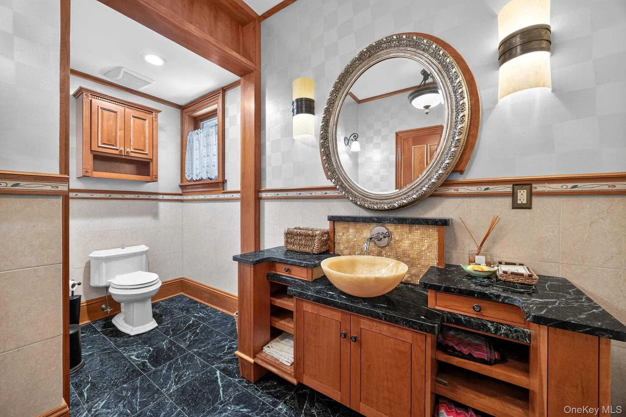 Vanity featuring a vessel sink, dark countertop, and custom cabinetry with open shelving Vanity featuring a vessel sink, dark countertop, and custom cabinetry with open shelving