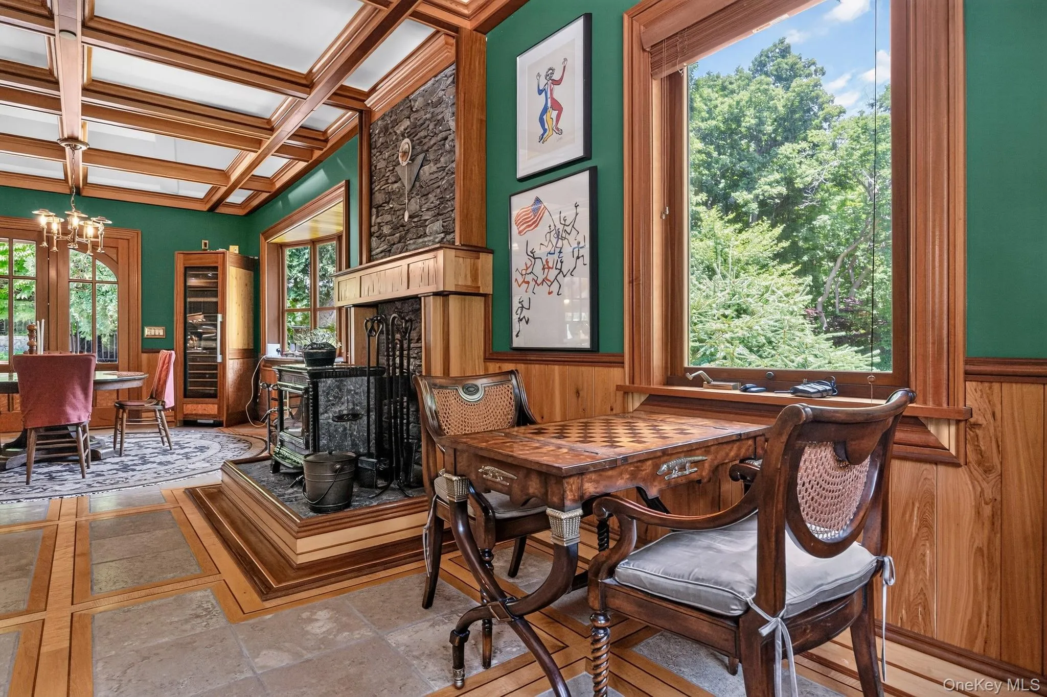 Interior room featuring a wood-paneled coffered ceiling and a prominent wood-burning stove on a raised hearth Interior room featuring a wood-paneled coffered ceiling and a prominent wood-burning stove on a raised hearth