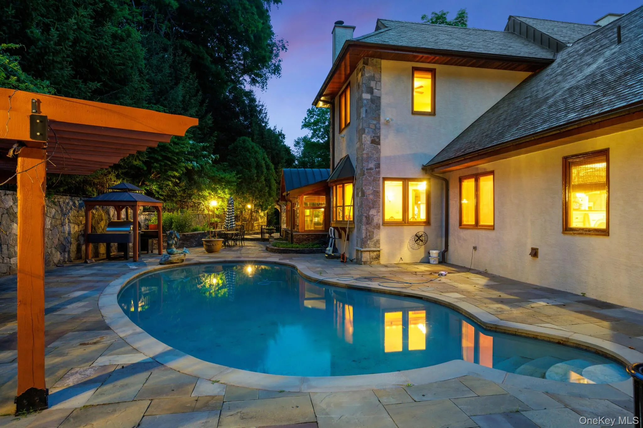 Freeform swimming pool surrounded by a paver patio Freeform swimming pool surrounded by a paver patio