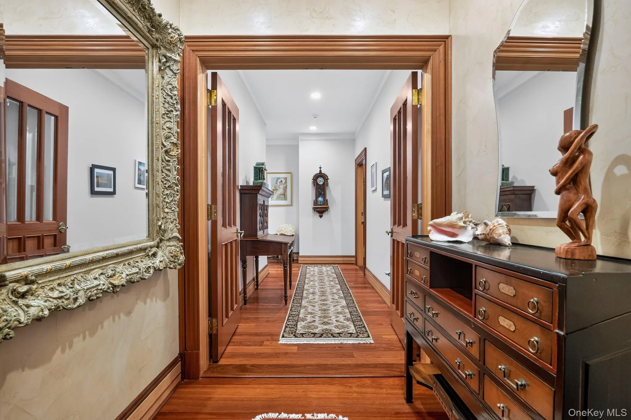 Entryway featuring wood-finish flooring, paneled wood doors, and decorative wall molding Entryway featuring wood-finish flooring, paneled wood doors, and decorative wall molding