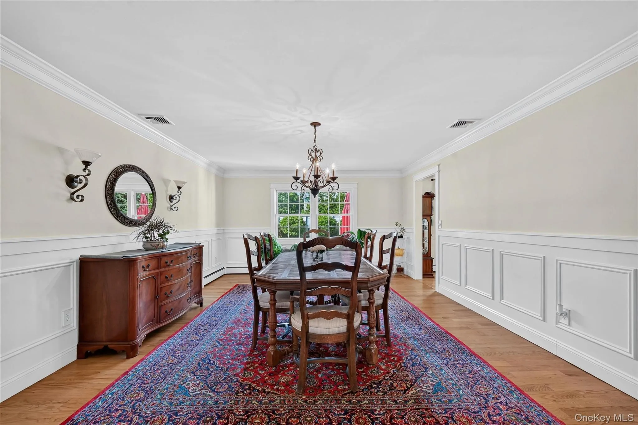The spacious dining room features classic wainscoting, hardwood floors, and an elegant setting for holidays, gatherings, and everyday meals. The spacious dining room features classic wainscoting, hardwood floors, and an elegant setting for holidays, gatherings, and everyday meals.