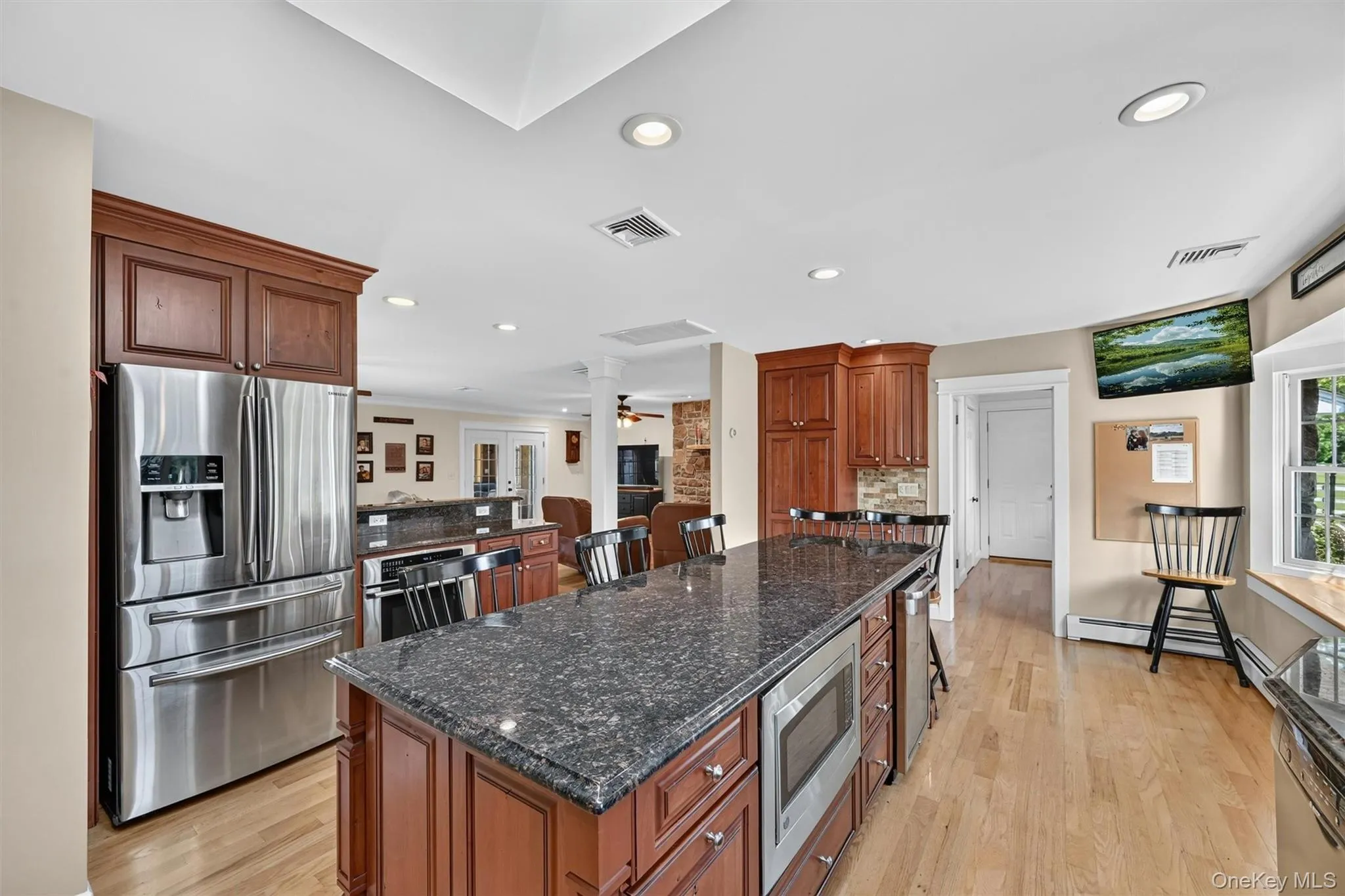 A spacious island anchors the kitchen, offering generous prep space, casual seating, granite countertops, stainless steel appliances, and thoughtful storage throughout. A spacious island anchors the kitchen, offering generous prep space, casual seating, granite countertops, stainless steel appliances, and thoughtful storage throughout.