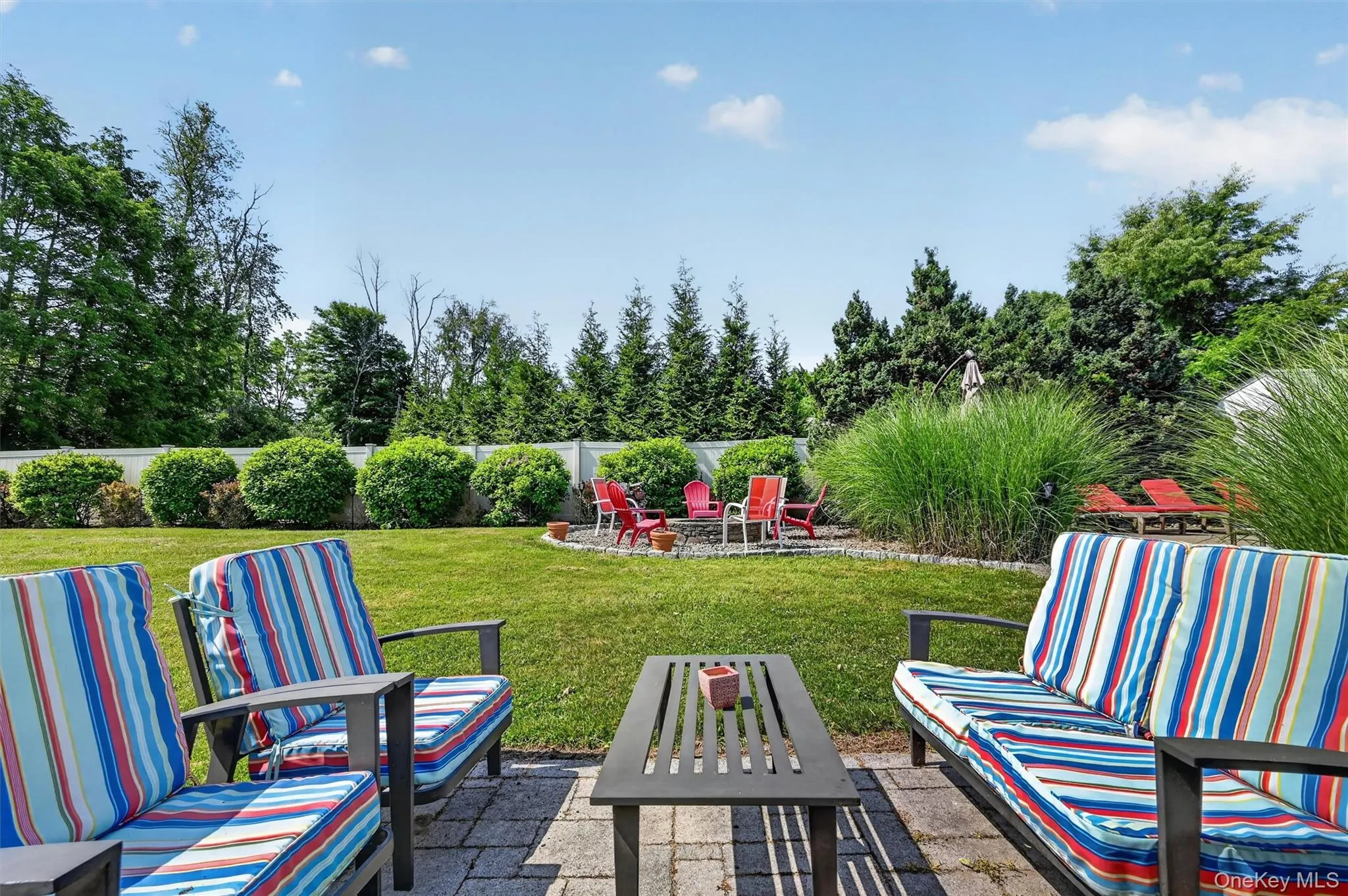 From this patio seating area, enjoy views of the private backyard, mature landscaping, and firepit area tucked into the outdoor setting. From this patio seating area, enjoy views of the private backyard, mature landscaping, and firepit area tucked into the outdoor setting.