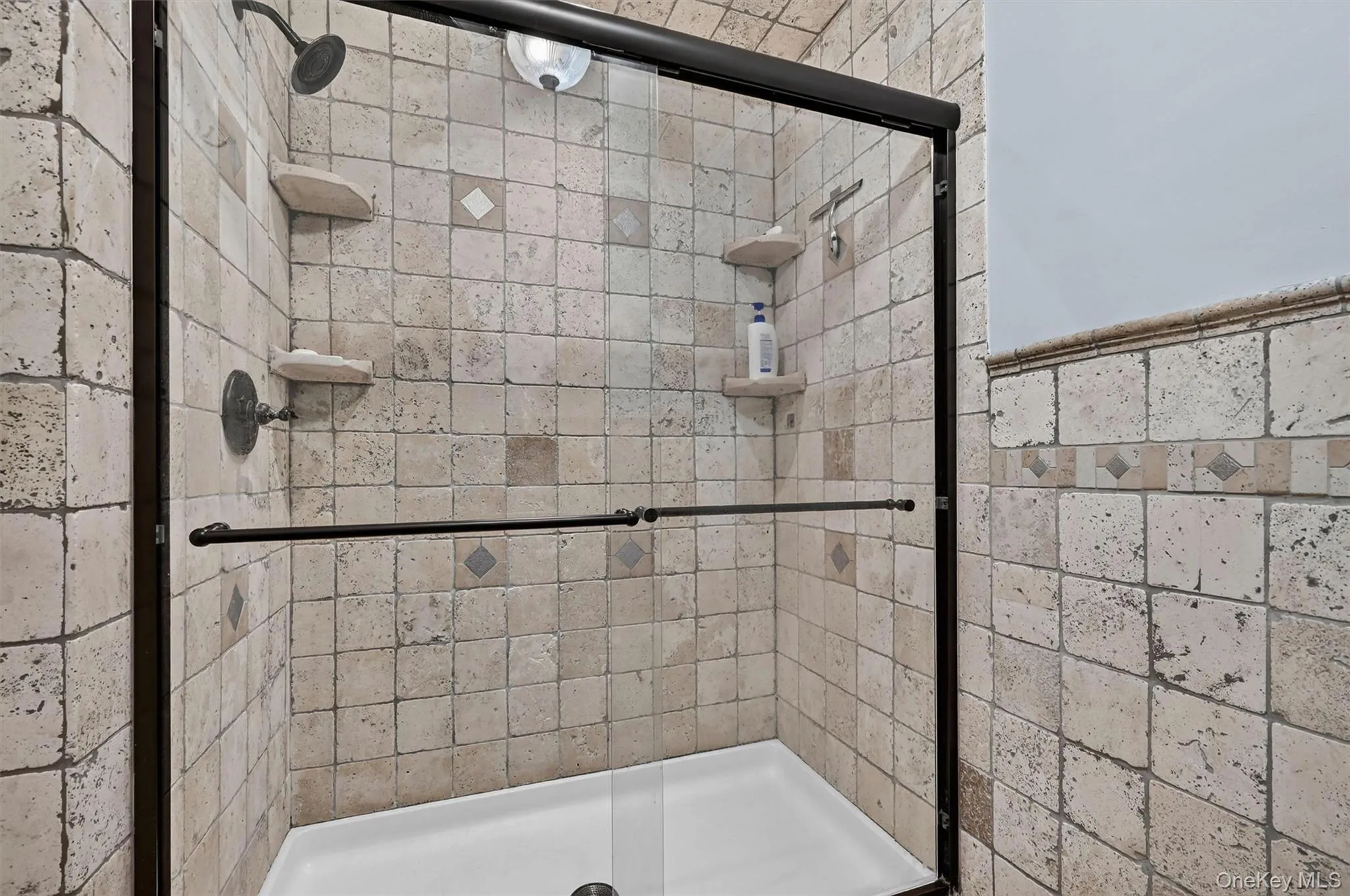 A tiled walk-in shower with glass doors adds function and timeless appeal to the updated primary bath. A tiled walk-in shower with glass doors adds function and timeless appeal to the updated primary bath.