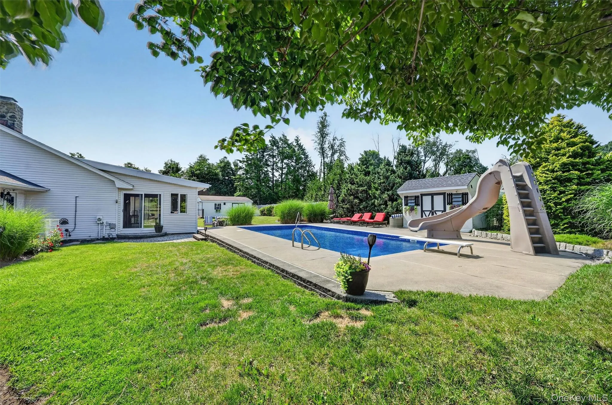 A true backyard retreat with an inground pool, multiple sitting areas, mature trees, privacy fencing, and space designed for summer enjoyment. A true backyard retreat with an inground pool, multiple sitting areas, mature trees, privacy fencing, and space designed for summer enjoyment.