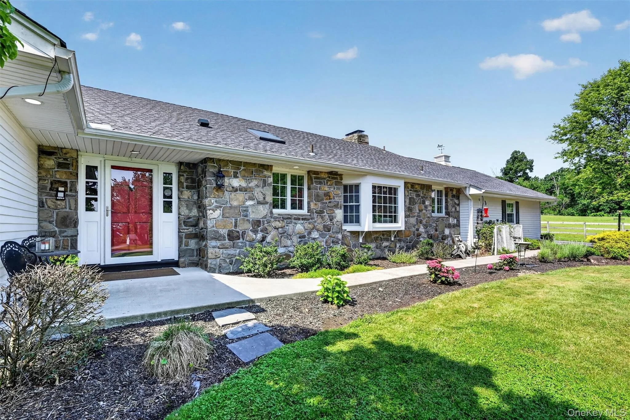 A closer look at the charming stone exterior, red front door, and manicured landscaping that give 5 Hedges Road its warm and timeless curb appeal. A closer look at the charming stone exterior, red front door, and manicured landscaping that give 5 Hedges Road its warm and timeless curb appeal.