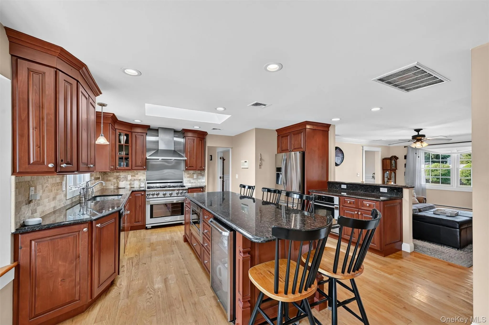 Designed for cooking and gathering, the kitchen features a 6-burner chef-inspired range, dual ovens, granite surfaces, rich cabinetry, and an easy connection to the family room. Designed for cooking and gathering, the kitchen features a 6-burner chef-inspired range, dual ovens, granite surfaces, rich cabinetry, and an easy connection to the family room.
