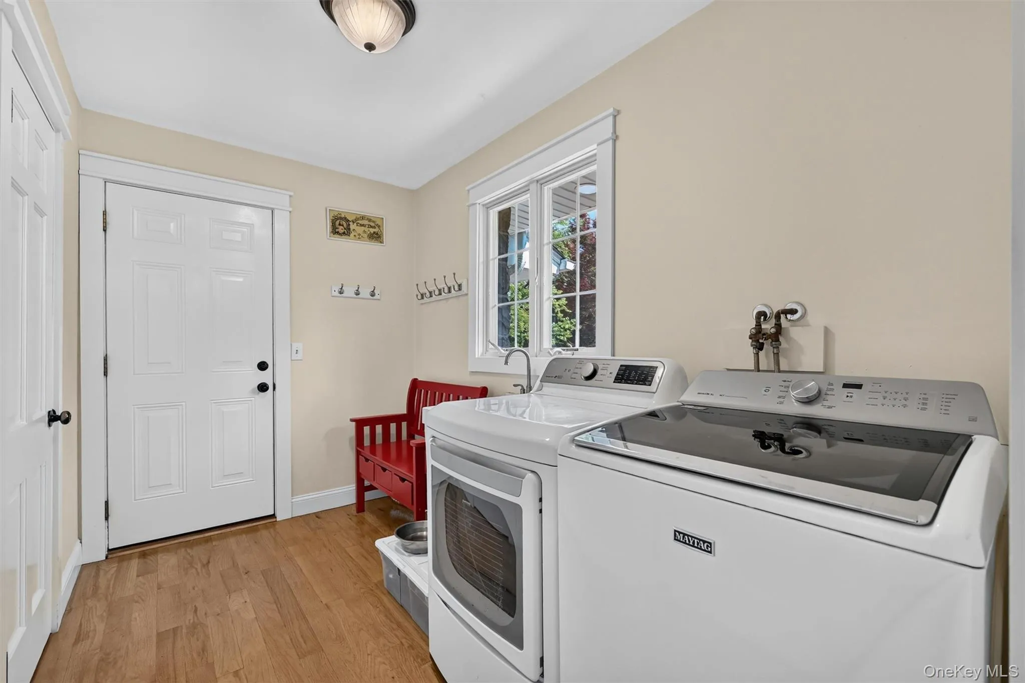 Positioned between the garage and kitchen, the mudroom/laundry room offers a practical drop zone with exterior access, laundry space, and a large pantry closet for added everyday storage. Positioned between the garage and kitchen, the mudroom/laundry room offers a practical drop zone with exterior access, laundry space, and a large pantry closet for added everyday storage.