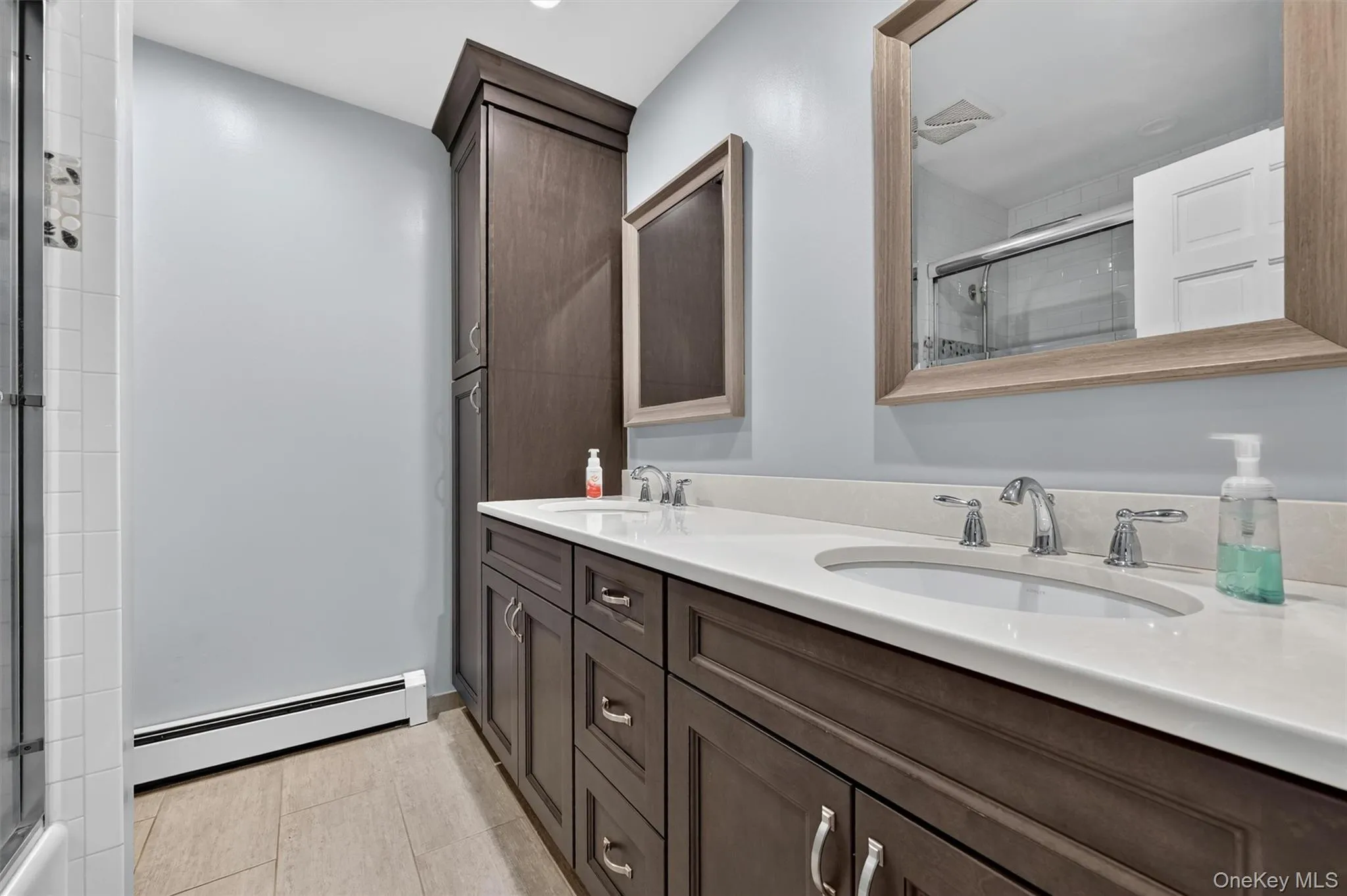 The updated hall bath features dual sinks, modern cabinetry, neutral finishes, and a clean, functional layout. The updated hall bath features dual sinks, modern cabinetry, neutral finishes, and a clean, functional layout.