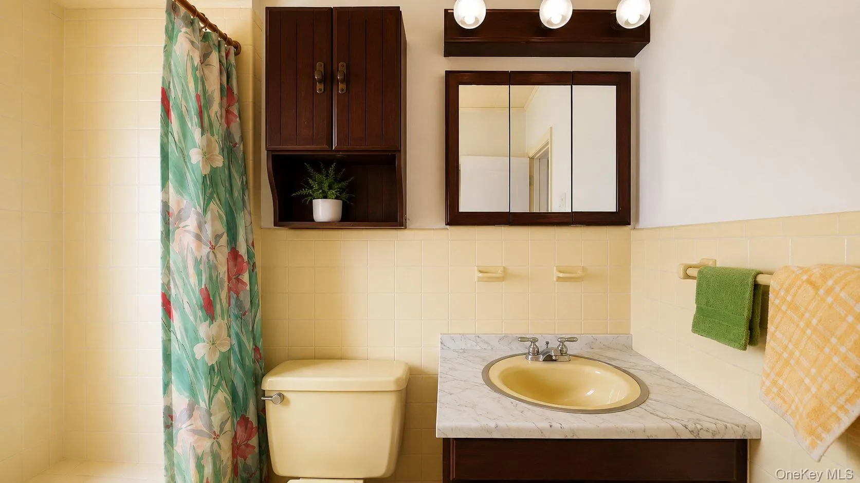 Bathroom featuring a marble-patterned countertop with an oval sink, a wall-mounted medicine cabinet, and overhead vanity lighting Bathroom featuring a marble-patterned countertop with an oval sink, a wall-mounted medicine cabinet, and overhead vanity lighting