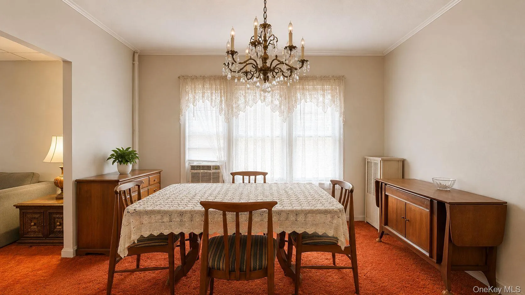 Dining area featuring a crystal chandelier, crown molding, and an accent wall Dining area featuring a crystal chandelier, crown molding, and an accent wall