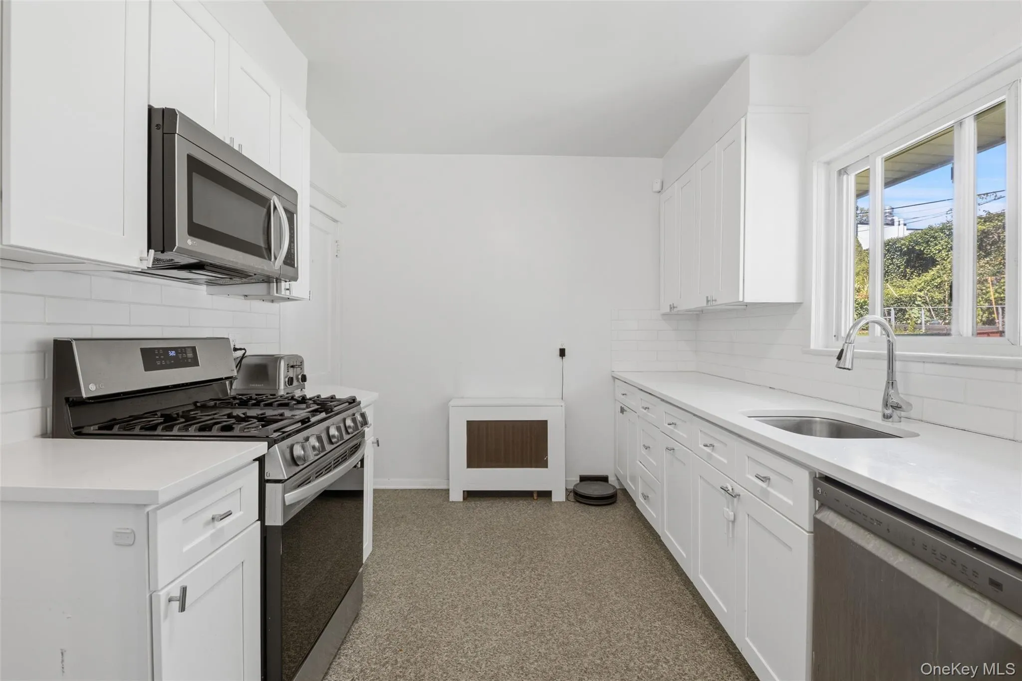 Beautifully renovated kitchen with crisp white cabinetry and plenty of natural light. Beautifully renovated kitchen with crisp white cabinetry and plenty of natural light.
