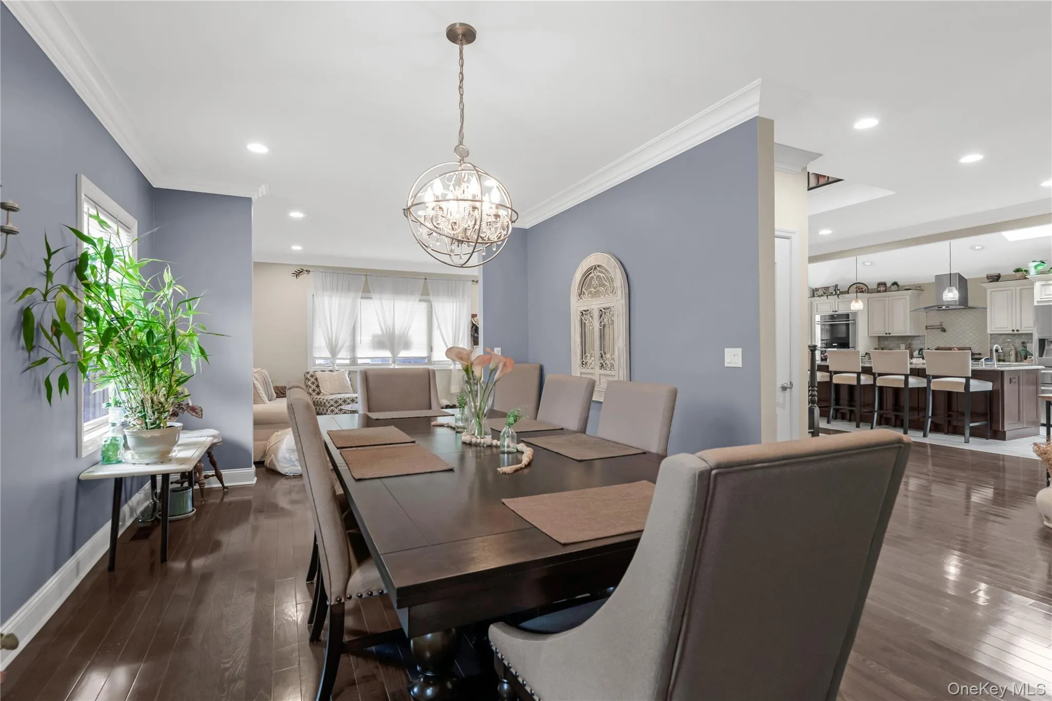 Formal dining area featuring rich wood-finish flooring, a contemporary chandelier, and crown molding Formal dining area featuring rich wood-finish flooring, a contemporary chandelier, and crown molding