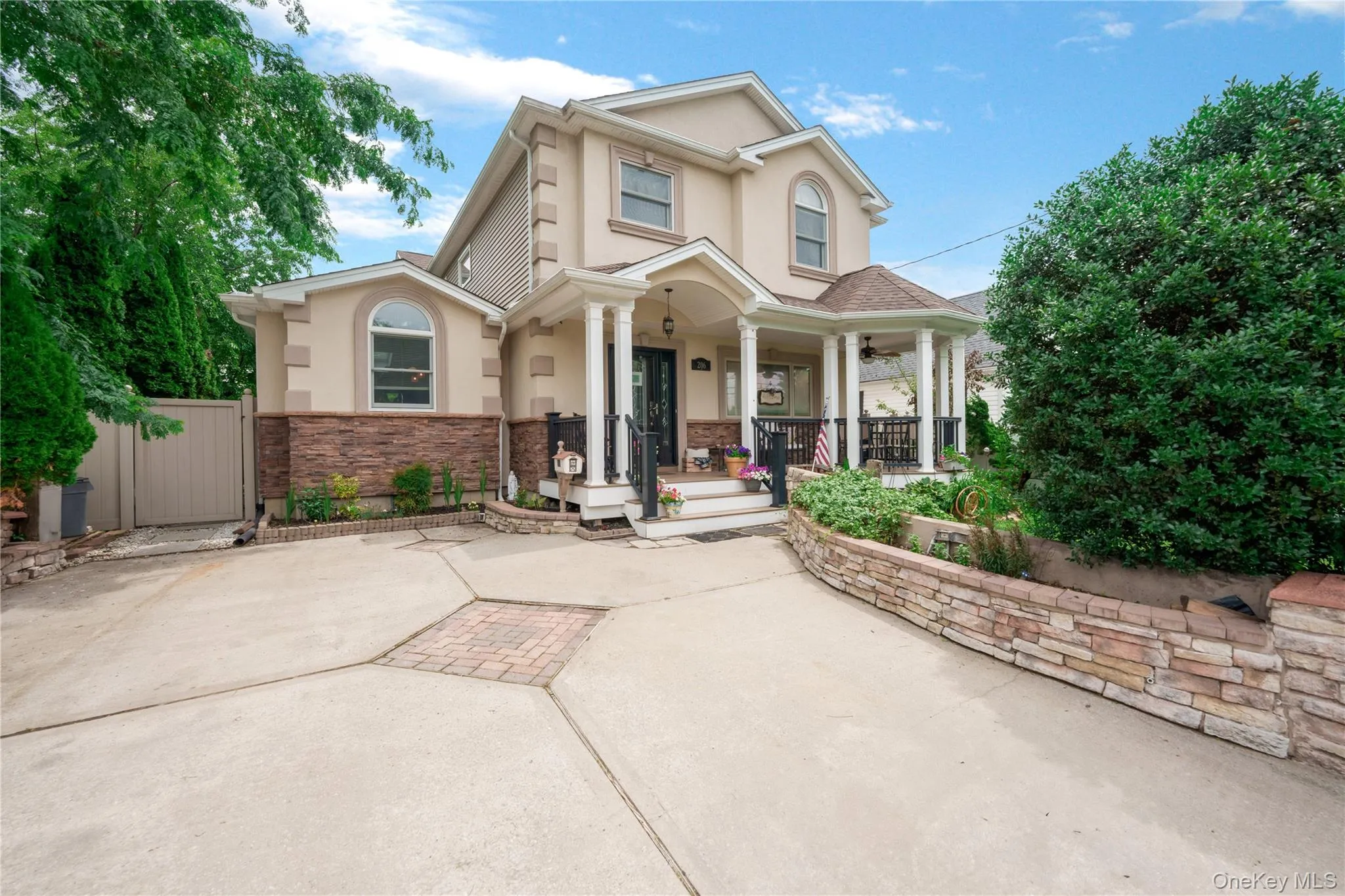 Stucco exterior featuring stone veneer accents and a covered front porch Stucco exterior featuring stone veneer accents and a covered front porch